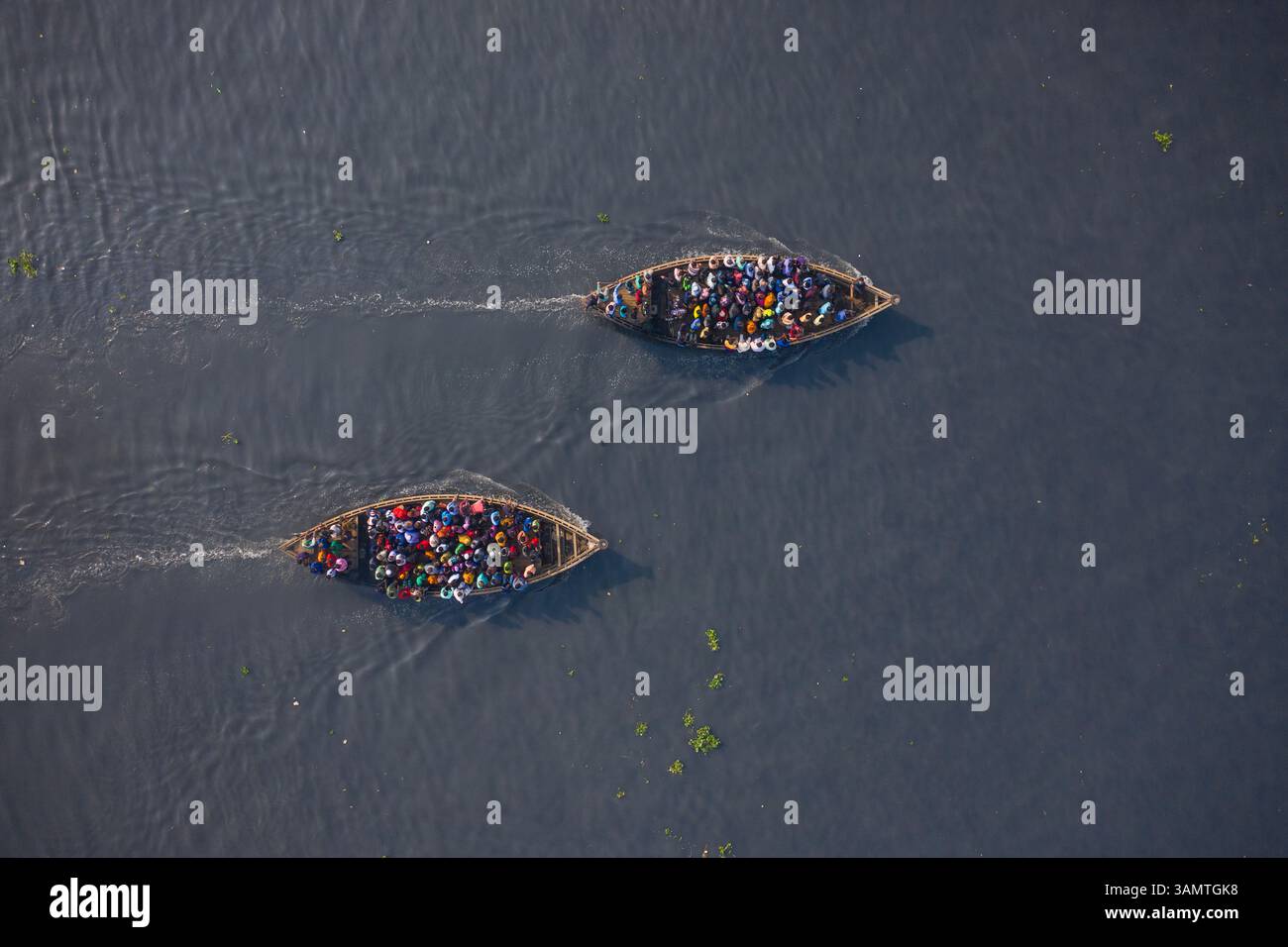 Vista aerea di due traghetti in legno pieni di passeggeri che attraversano il fiume Shitalakshya a Bandar, divisione Dhaka, Bangladesh. Foto Stock