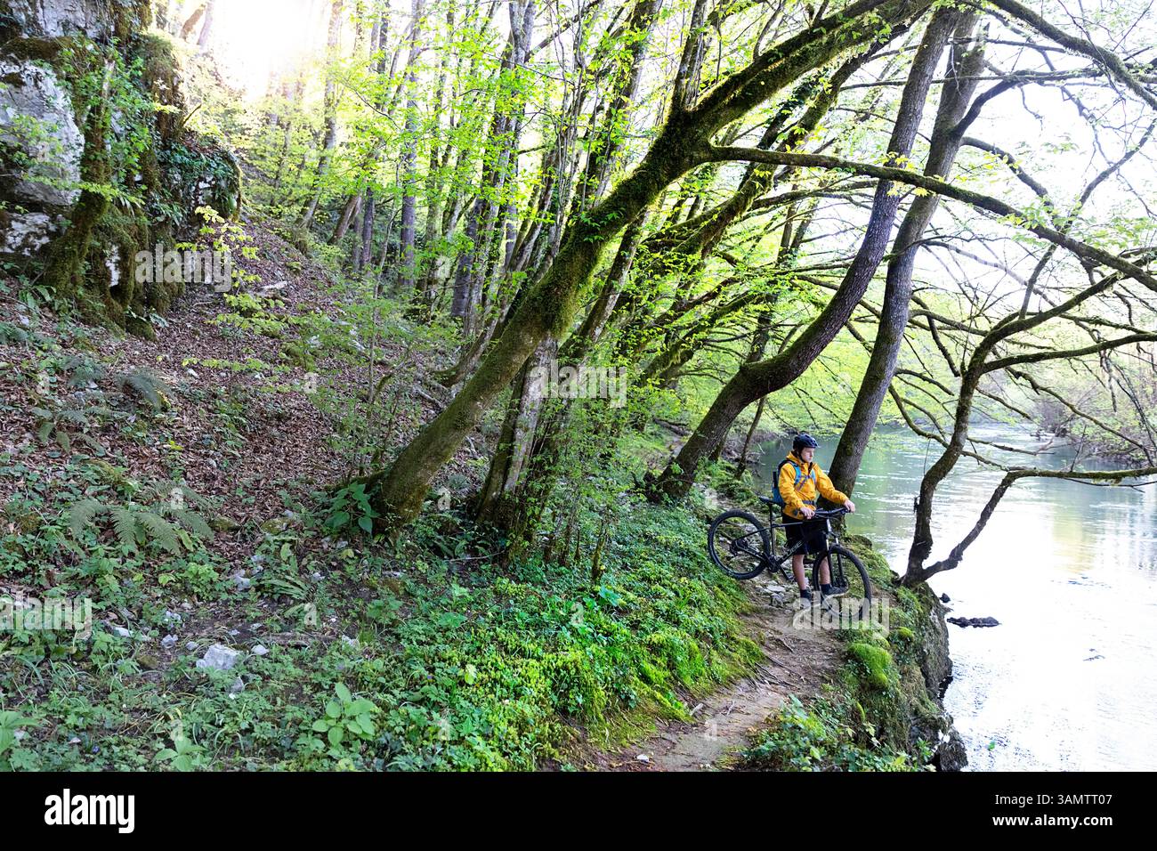Bambino turistico in gita in bicicletta nella regione di dolenjska, in bicicletta su strade sterrate e sentieri lungo il fiume krka, circondato dalla foresta, novo mesto, slovenia Foto Stock