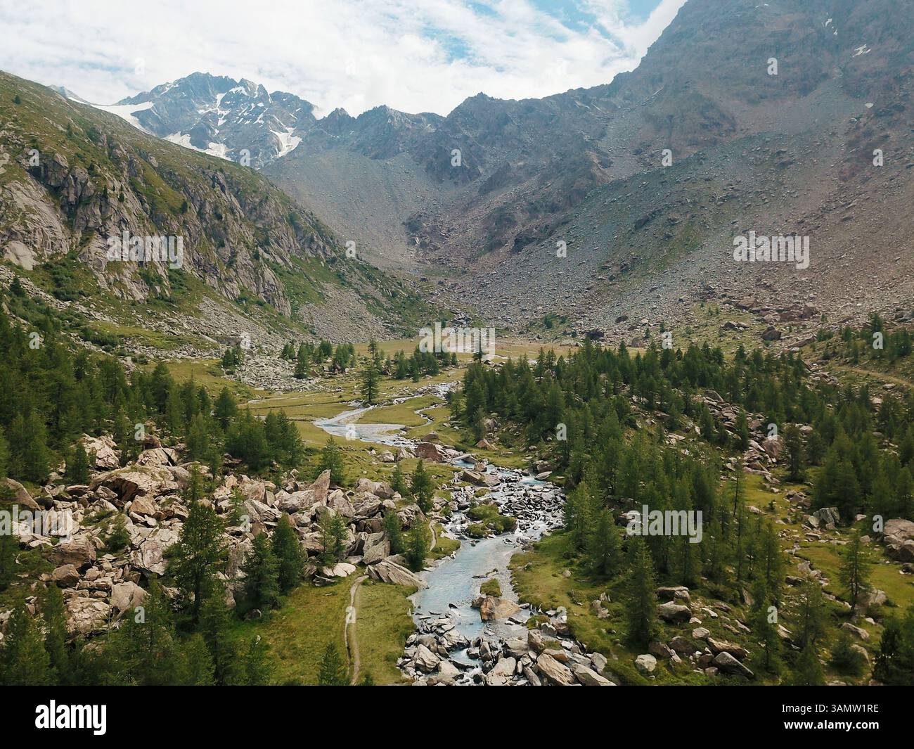 Veduta aerea di uno splendido fiume alpino che scorre attraverso la valle preda Rossa con in lontananza la catena montuosa della Disgrazia, Val Masino, Lombardia Foto Stock