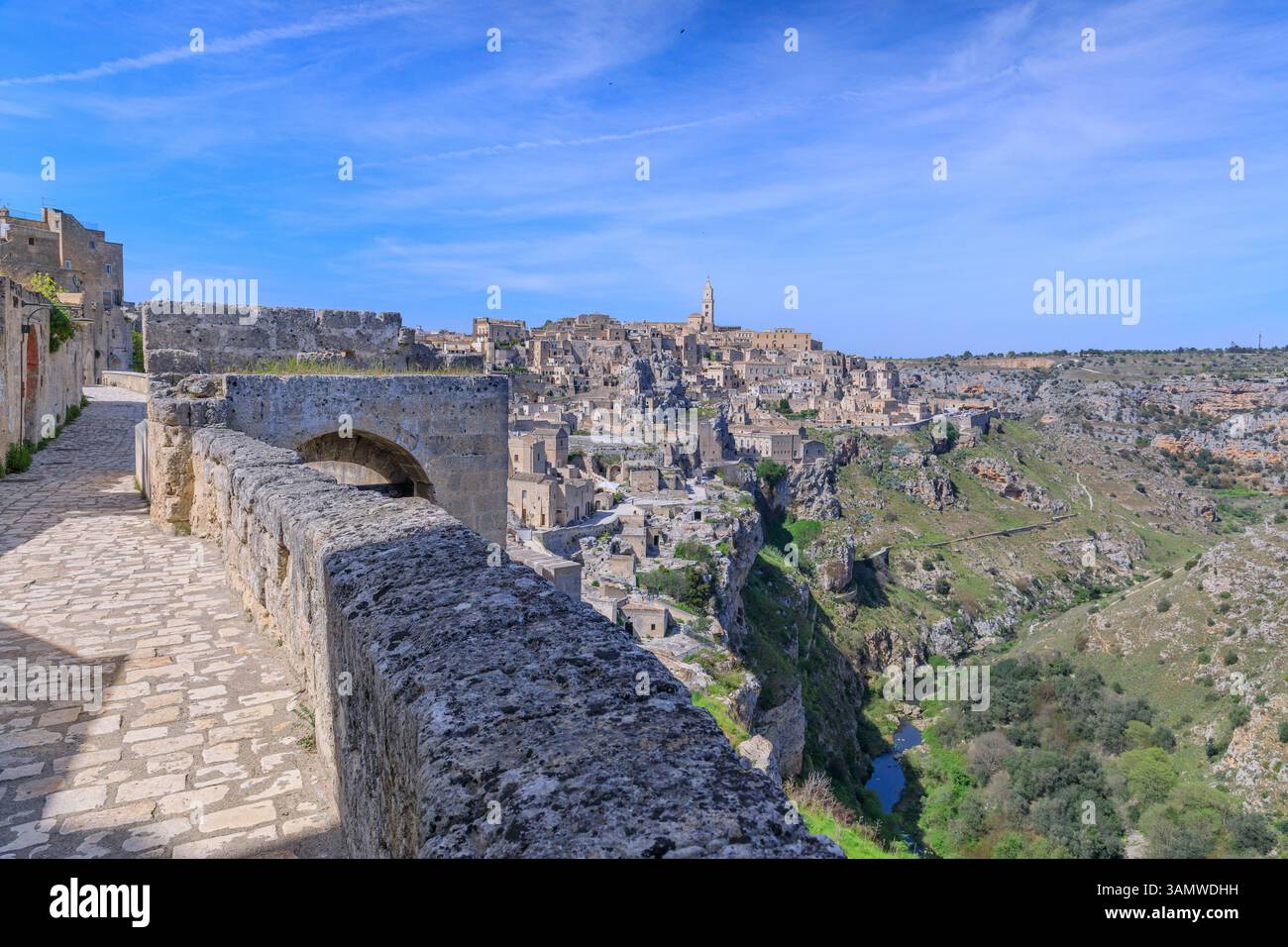 Paesaggio urbano dei Sassi di Matera dalla tipica strada asfaltata del sud Italia: Veduta della riserva naturale della Murgia Materana e delle Chiese delle Grotte. Foto Stock