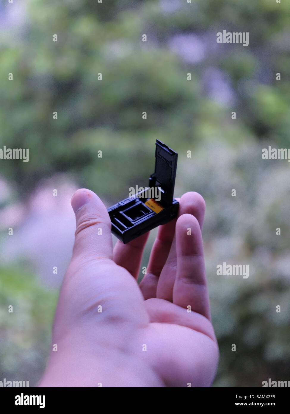 Obiettivo retrò in mani moderne: Fotocamera in miniatura che riflette la fusione di Nostalgia, tradizione e innovazione digitale dei giovani cinesi Foto Stock