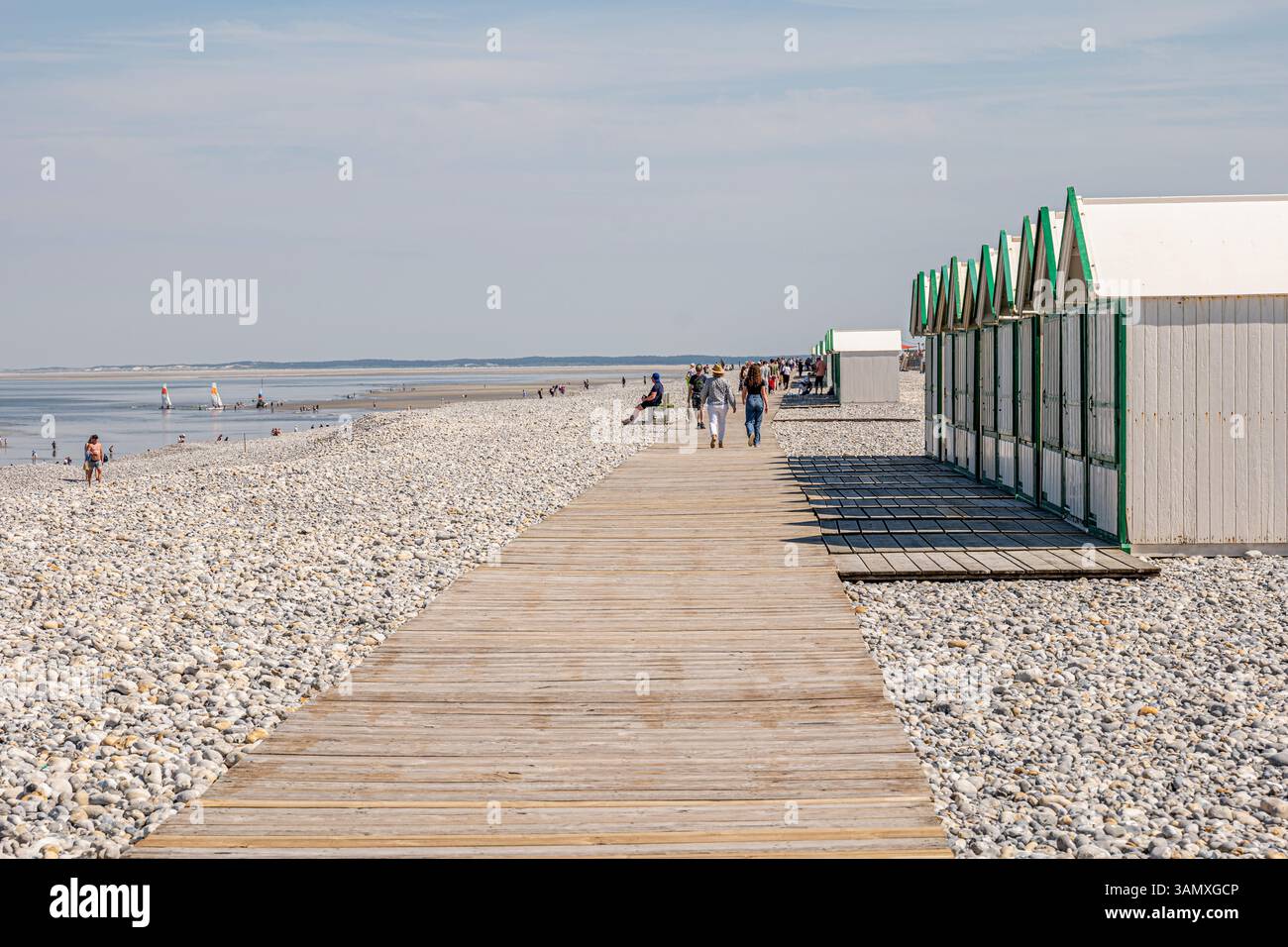 Cayeux-sur-Mer (Francia settentrionale): Rifugi e turisti sulla passerella in legno "chemin des Planches" lungo la spiaggia di ciottoli. Foto Stock