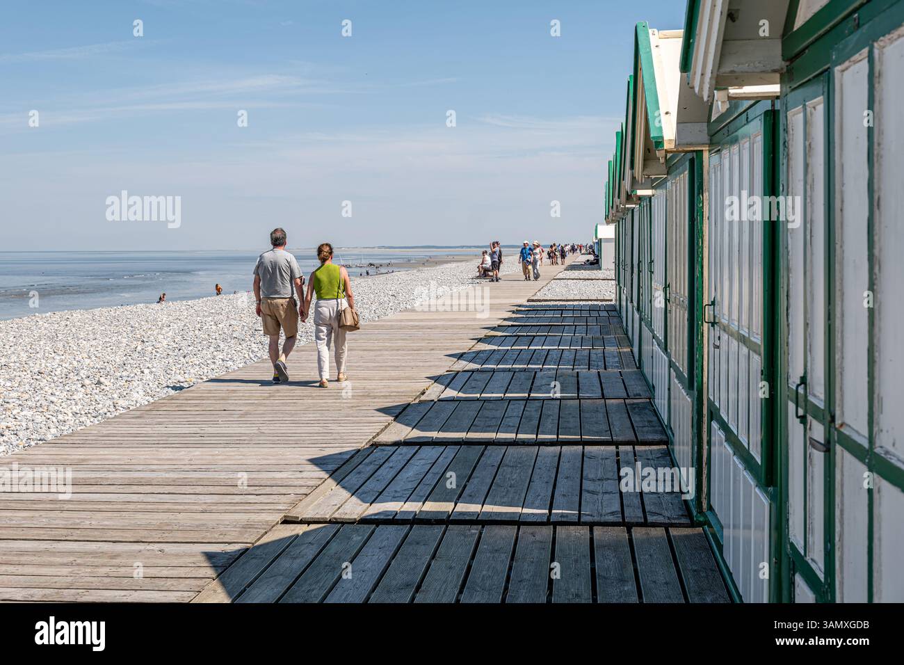 Cayeux-sur-Mer (Francia settentrionale): Rifugi e turisti sulla passerella in legno "chemin des Planches" lungo la spiaggia di ciottoli. Foto Stock