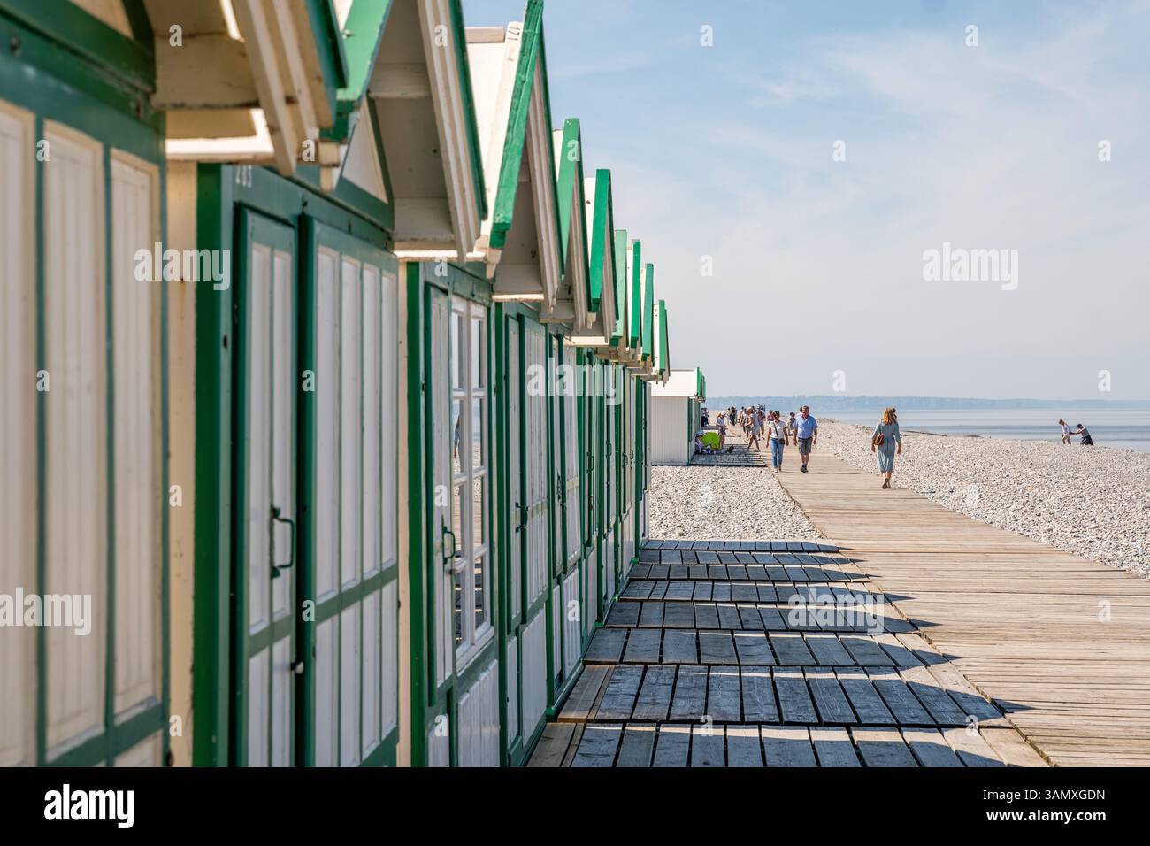 Cayeux-sur-Mer (Francia settentrionale): Rifugi e turisti sulla passerella in legno "chemin des Planches" lungo la spiaggia di ciottoli. Foto Stock