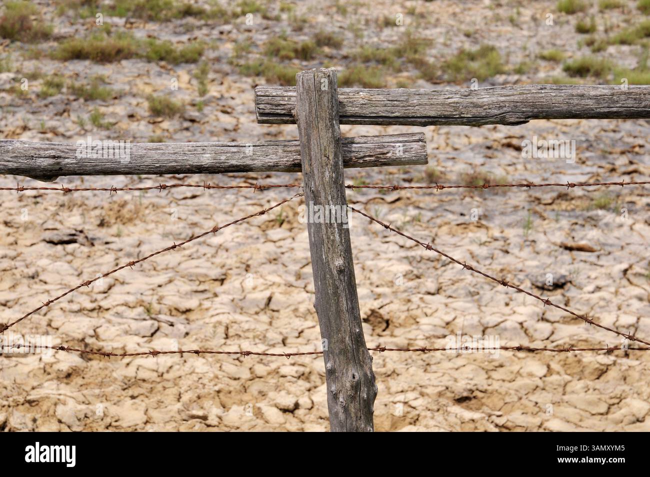 vecchio punto di iniezione in filo spinato e terreno asciutto Foto Stock