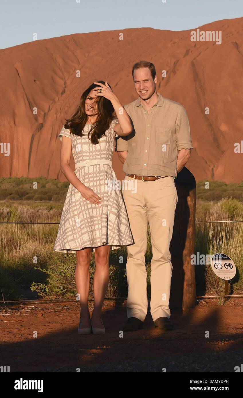 22 aprile 2014 - Yulara, AUSTRALIA - il principe William britannico si erge come sua moglie, Kate, duchessa di Cambridge, si adatta i capelli mentre posa per una foto al tramonto a Uluru, Australia, martedì 22 aprile 2014. William e Kate hanno ricevuto un tradizionale benvenuto aborigeno durante una visita alla minuscola cittadina di Yulara, vicino al monolite rosso brillante di arenaria Uluru, noto anche come Ayers Rock, nell'Outback australiano. (Immagine di credito: © Prensa Internacional/ZUMAPRESS.com) Foto Stock