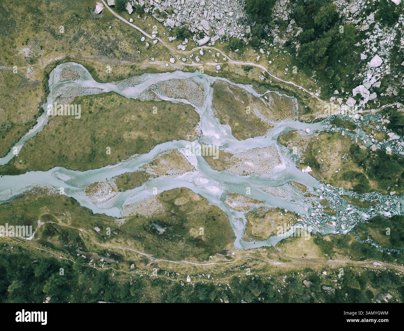 Veduta aerea di un fiume rivuleti che trasportano sedimenti dal ghiacciaio, la valle preda Rossa, la Val Masino, Italia. Foto Stock