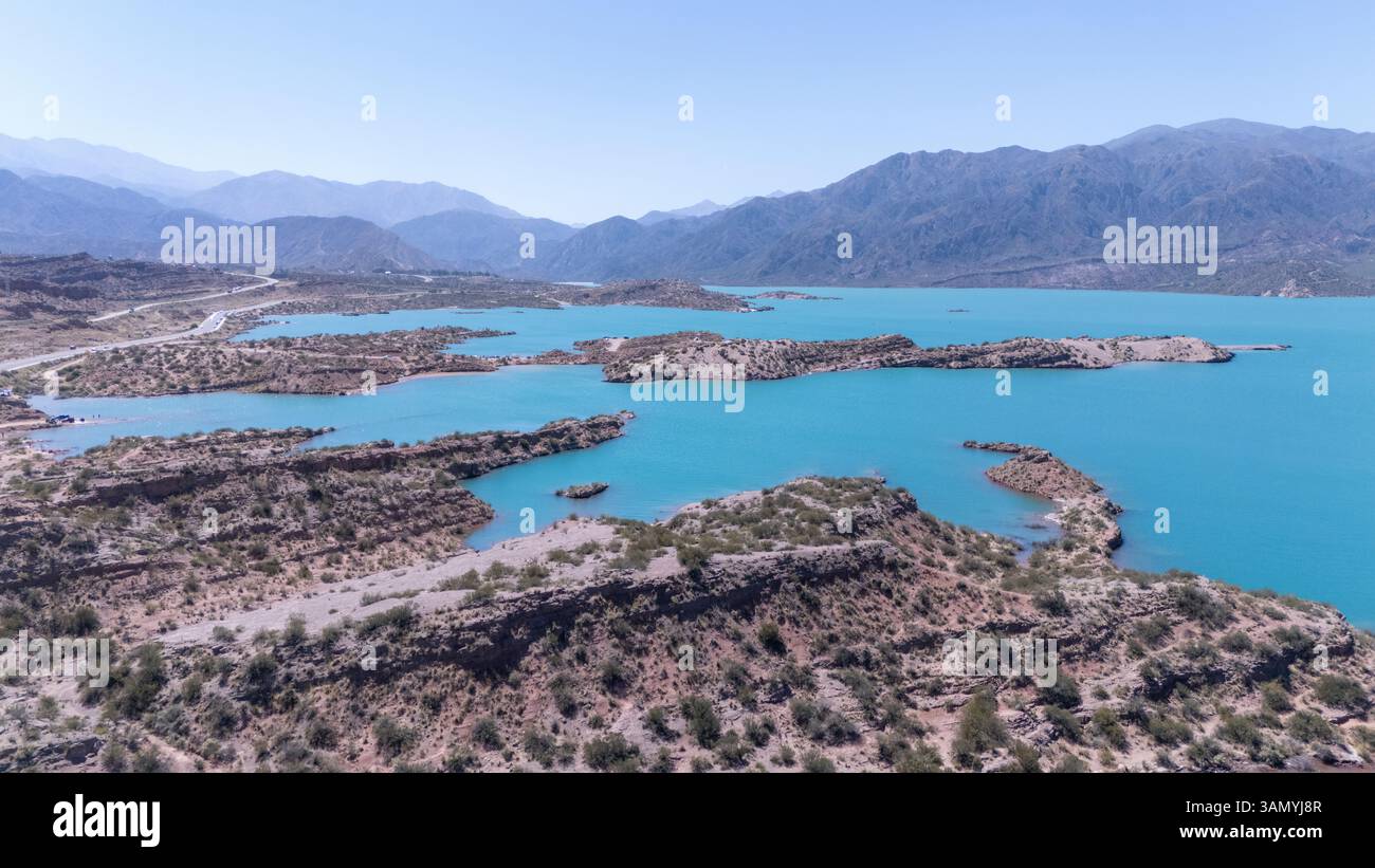 Vista aerea del tranquillo lago Potrerillos circondato da montagne maestose e cielo azzurro, Potrerillos, Mendoza, Argentina. Foto Stock