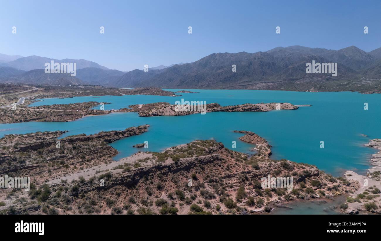 Vista aerea del tranquillo lago Potrerillos circondato da montagne maestose e cielo azzurro, Potrerillos, Mendoza, Argentina. Foto Stock