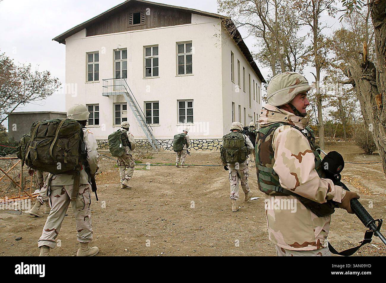 25 ottobre 2004 - Bagram Air Field, Afghanistan - Humanitarian Aid story..SSG. Charley Briddick (a destra) fa la guardia come soldati della 221st Ordnance Company e la 725th Logistical Task Force si avvicinano ad una scuola conosciuta come ''The White House'' appena fuori dal Bagram Air Field in Afghanistan lunedì mattina con aiuti umanitari per i bambini attraverso forniture scolastiche, articoli da toeletta e giocattoli. (Immagine di credito: © Aaron Suozzi/MCT/ZUMAPRESS.com) Foto Stock