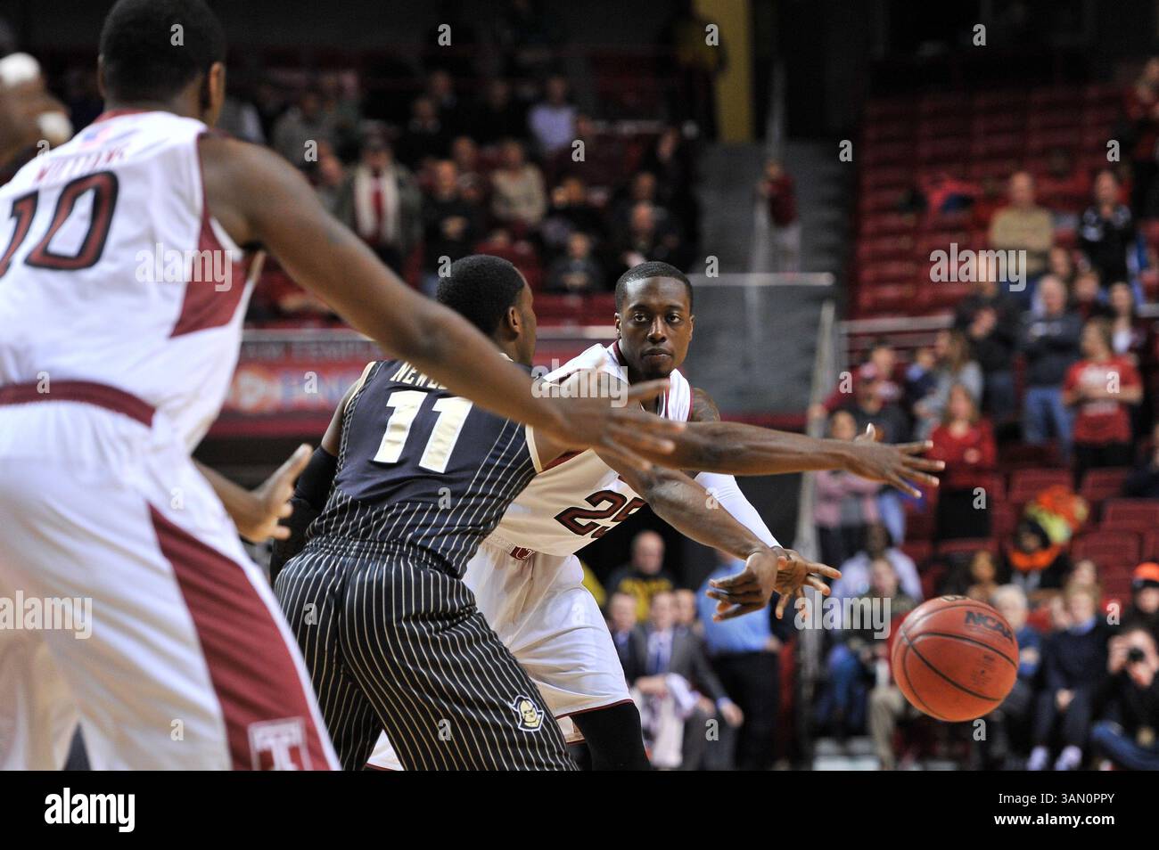 4 marzo 2014 - Filadelfia, Pennsylvania, U. S - la guardia dei Temple Owls QUENTON DECOSEY (25) passa la palla nel palo intorno alla guardia dei Cavalieri UCF CALVIN NEWELL (11) durante la partita di basket AAC tra i Cavalieri UCF e i Temple Owls giocata al Liacouras Center di Philadelphia. Temple ha battuto UCF nella finale casalinga dei Owls 86-78 ai tempi supplementari (Credit Image: © Ken Inness/ZUMAPRESS.com) Foto Stock