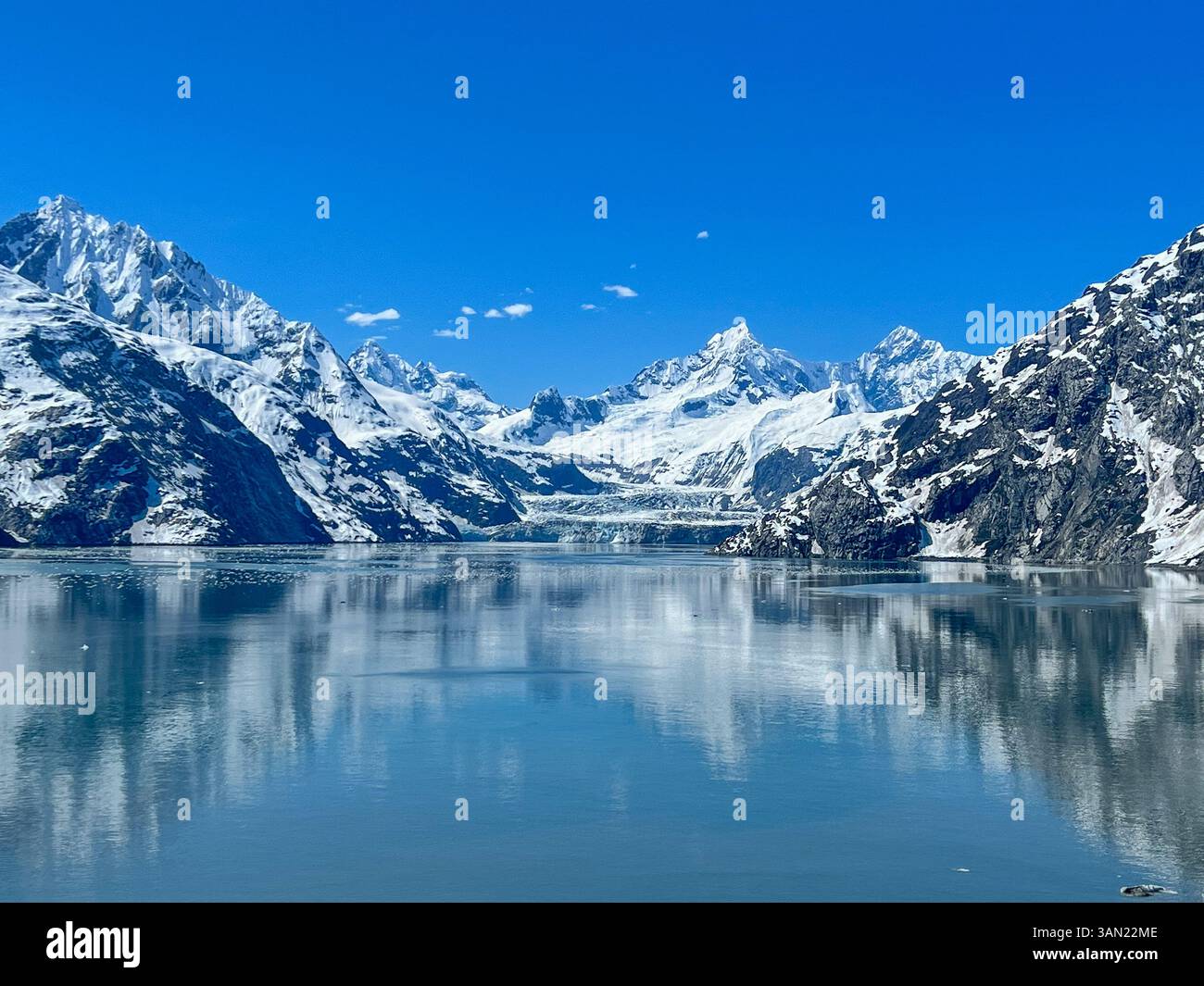 Una vista mozzafiato del Parco Nazionale di Glacier Bay, dove torreggianti cime innevate si riflettono sulle acque cristalline. Una vera testimonianza dell'untouc - Immagine stock catturata con smartphone