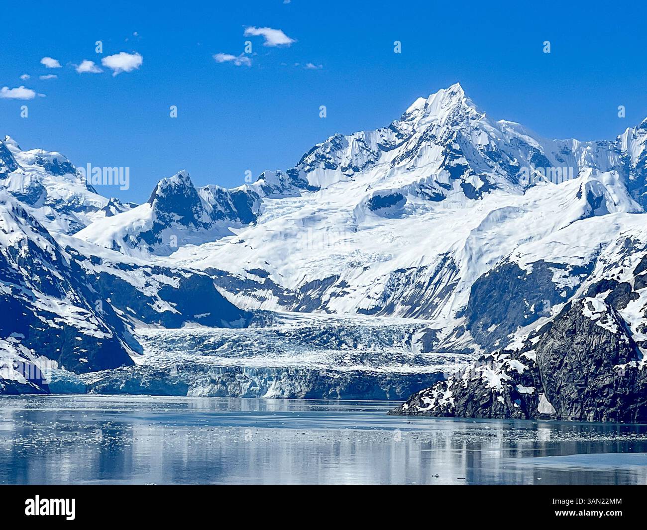 Una vista mozzafiato del Parco Nazionale di Glacier Bay, dove torreggianti cime innevate si riflettono sulle acque cristalline. Una vera testimonianza dell'untouc - Immagine stock catturata con smartphone
