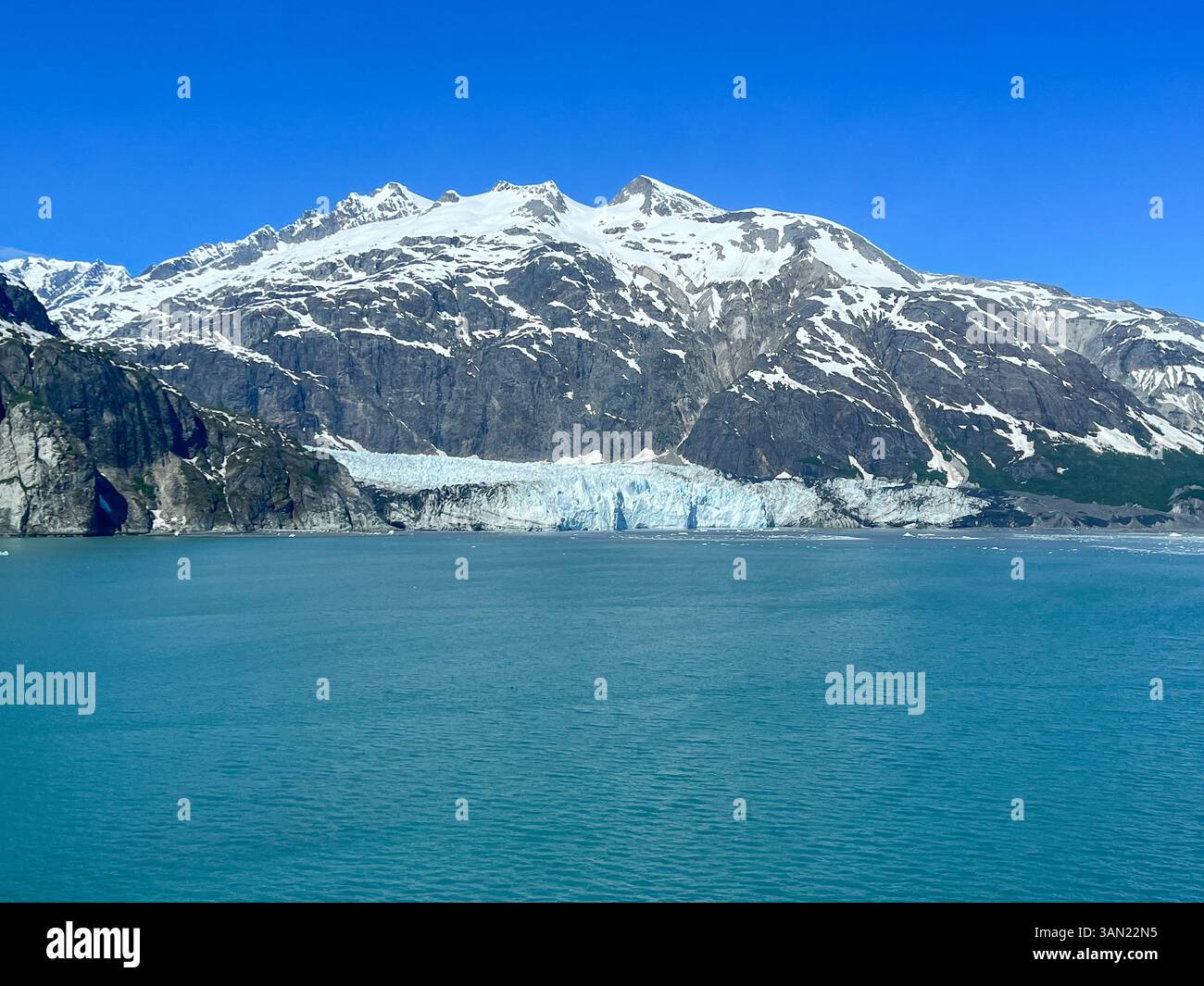 Una vista mozzafiato delle montagne innevate di Glacier Bay e delle aspre coste rocciose, circondate da acque turchesi incontaminate. Un vero deserto dell'Alaska - Immagine stock catturata con smartphone