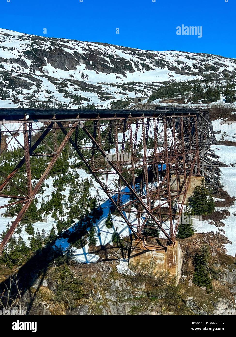 Questo ponte in acciaio abbandonato a White Pass, Alaska, si erge come un residuo storico della prima era ferroviaria. Una volta una parte cruciale del White Pass & Yuk - Immagine stock catturata con smartphone