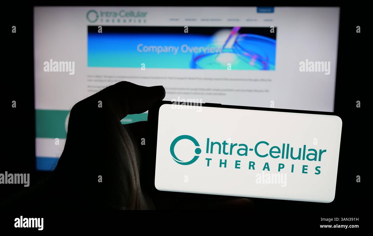 Stoccarda, Germania - 11-28-2024: Persona che tiene un telefono cellulare con logo della società biotecnologica statunitense Intra-Cellular Therapies Inc. Sullo schermo Foto Stock