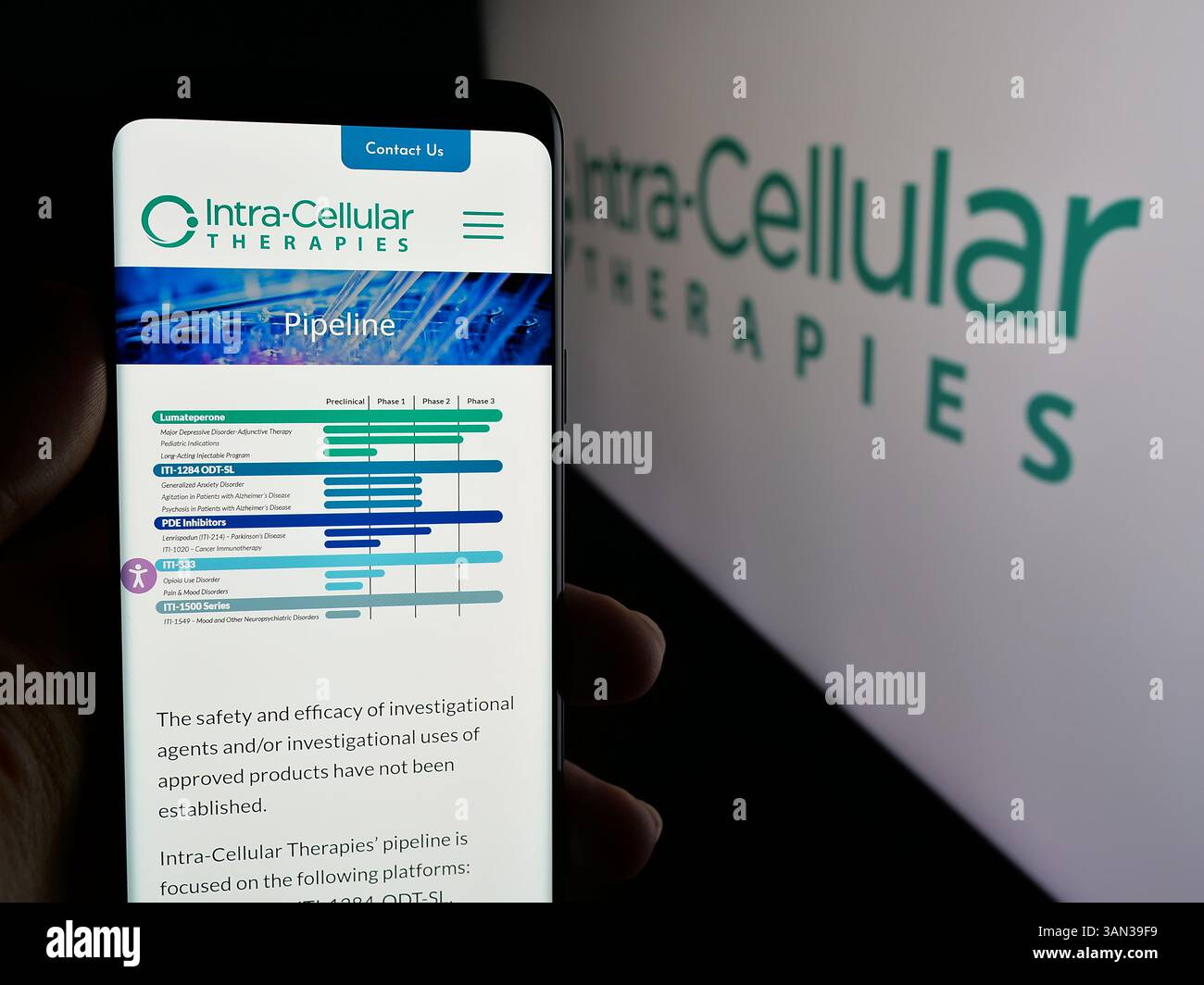 Stoccarda, Germania - 11-28-2024: Persona che tiene in mano uno smartphone con pagina web della società biotecnologica statunitense Intra-Cellular Therapies Inc. Con logo. Foto Stock
