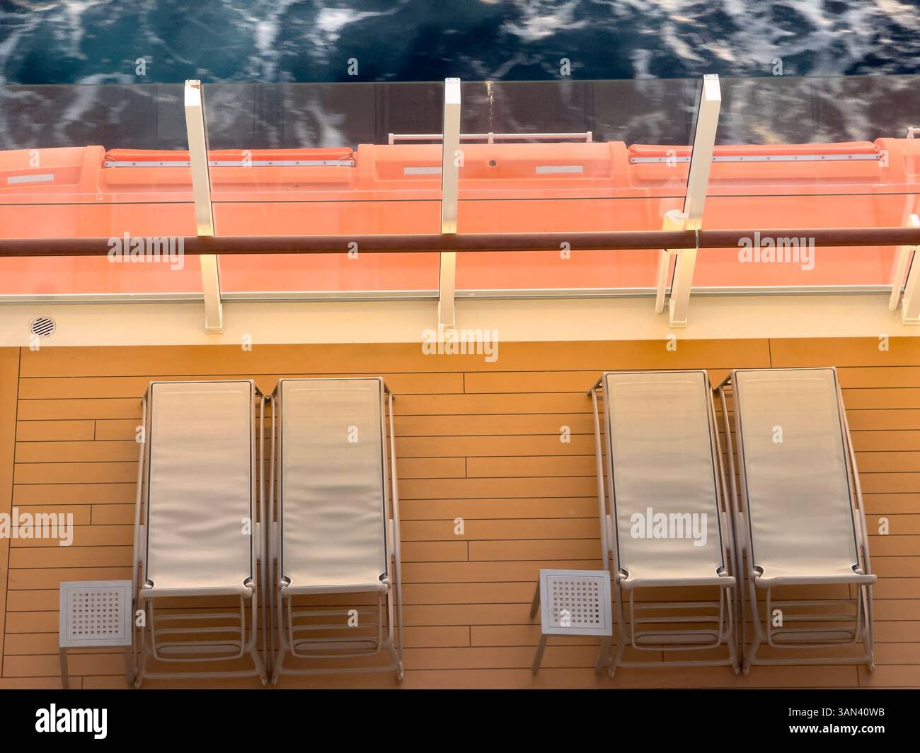 Lettini sul ponte delle navi da crociera con mare e onde che passano, tramonto Foto Stock