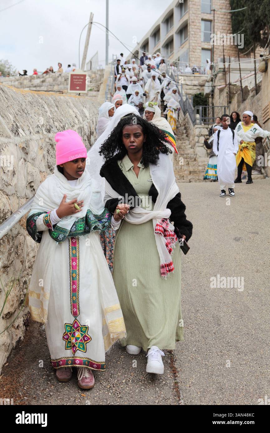 Processione della domenica delle Palme, pellegrini cristiani etiopi principalmente donne e pochi bambini a piedi dal Monte Olive che commemorano la corsa di Cristo su una colata fino a Gerusalemme. Foto Stock