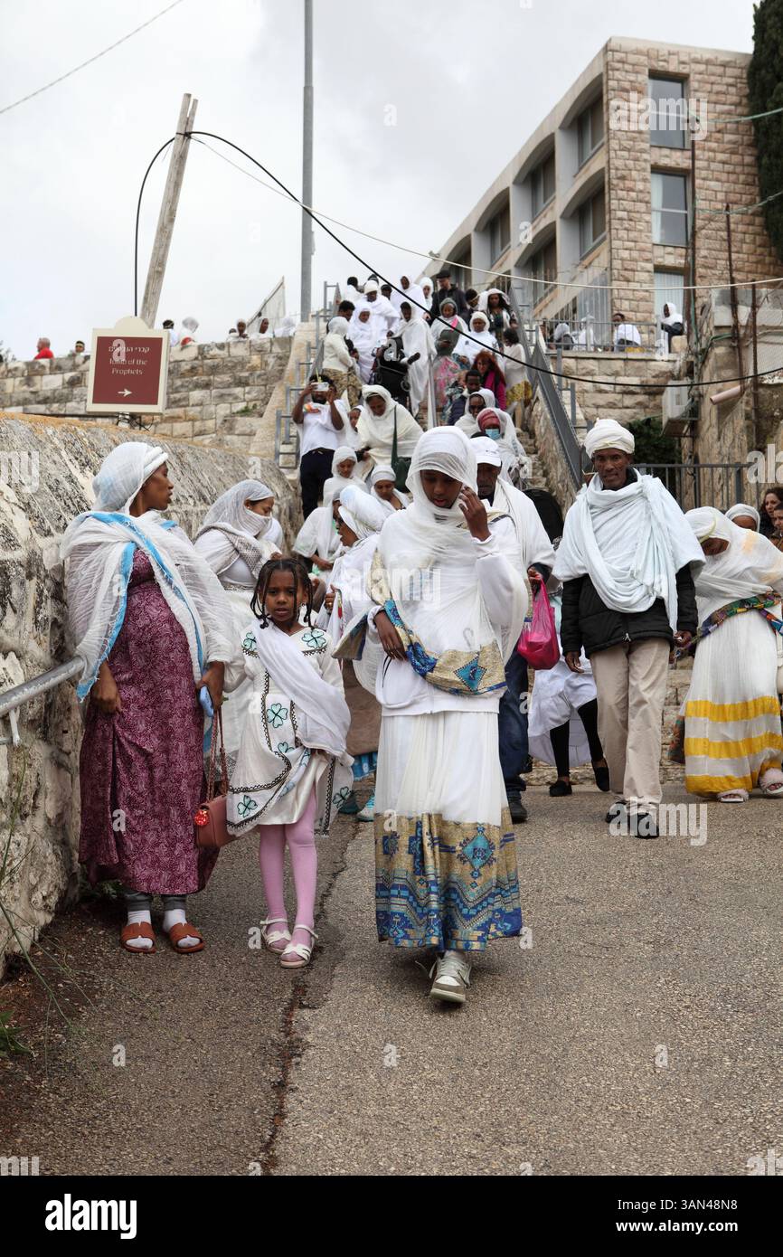 Processione della domenica delle Palme, pellegrini cristiani etiopi principalmente donne e pochi bambini a piedi dal Monte Olive che commemorano la corsa di Cristo su una colata fino a Gerusalemme. Foto Stock
