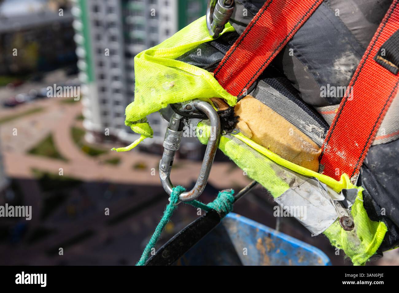 Vista dettagliata delle imbracature e delle attrezzature di sicurezza per lavori di costruzione a ripiani, con colori brillanti e sistemi di fissaggio sicuri per un lavoratore ottimale Foto Stock