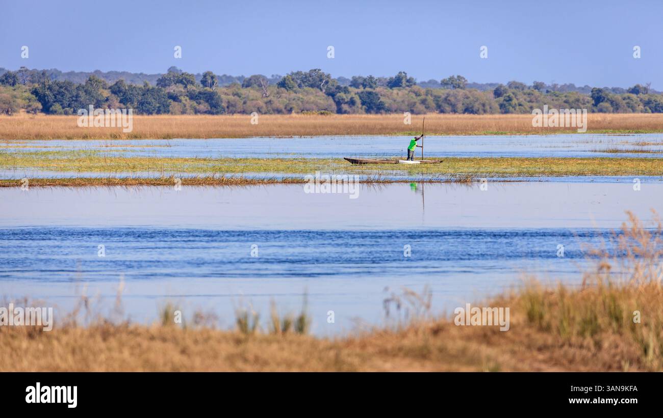 15 giugno 2018, Chobe National Park, Botswana: L'uomo locale pesca in barca dalla sua canoa nel fiume Chobe in Botswana Foto Stock