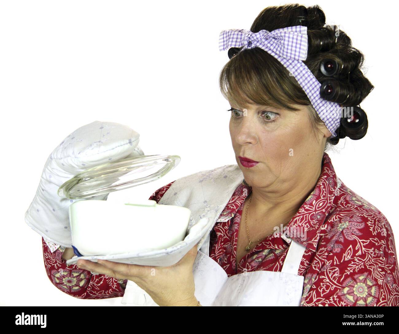 La casalinga Frumpy riceve una sorpresa guardando il piatto da forno Foto Stock