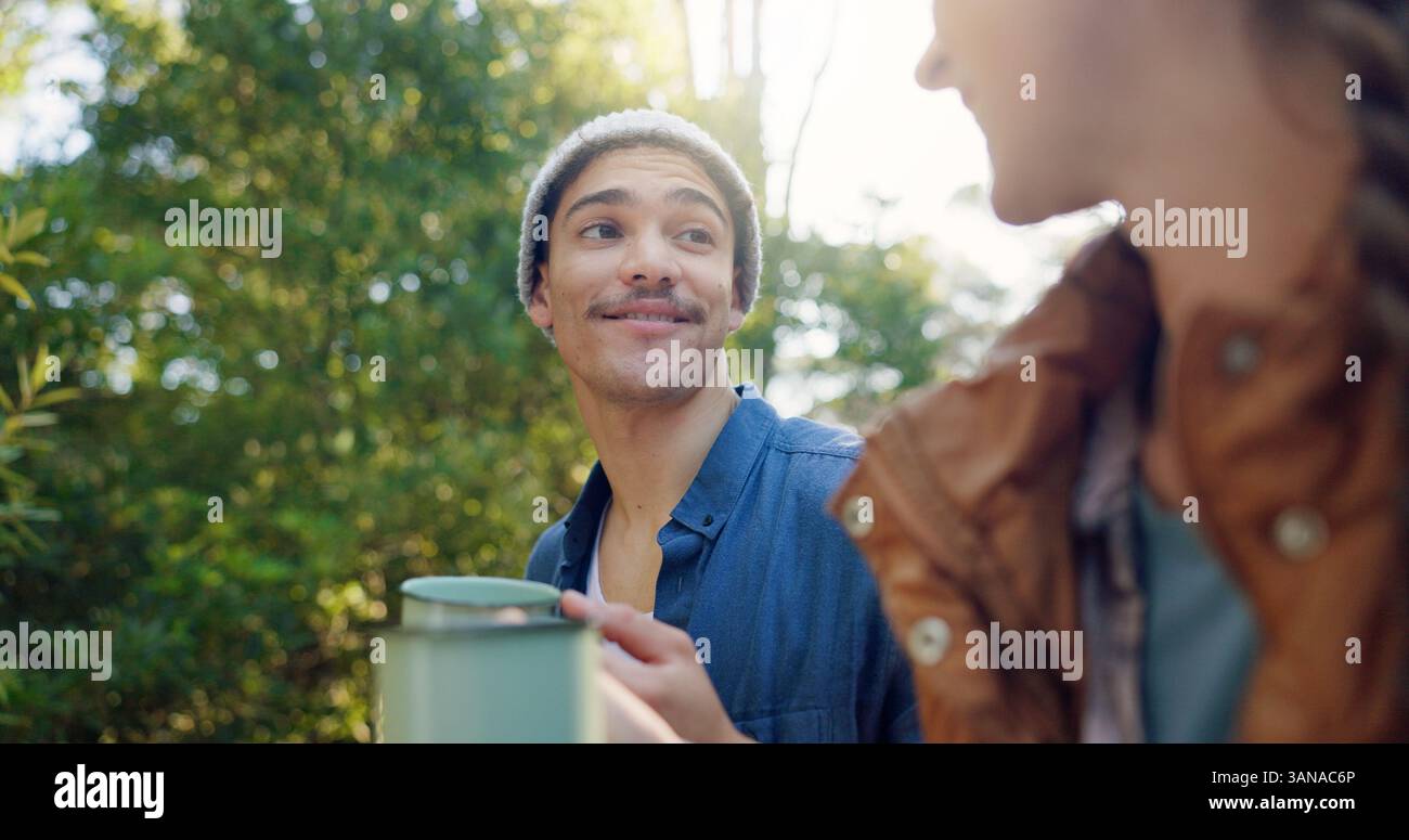 All'aperto, campeggio e coppia con caffè, sorriso e bevande calde in natura e avventura. Foresta, viaggi e persone con tè caldo per freddo Foto Stock