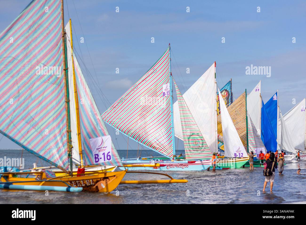 I Paraws, o le barche locali filippine con le loro enormi vele, fiancheggiano la spiaggia durante il Paraw Festival a Iloilo, nelle Filippine Foto Stock