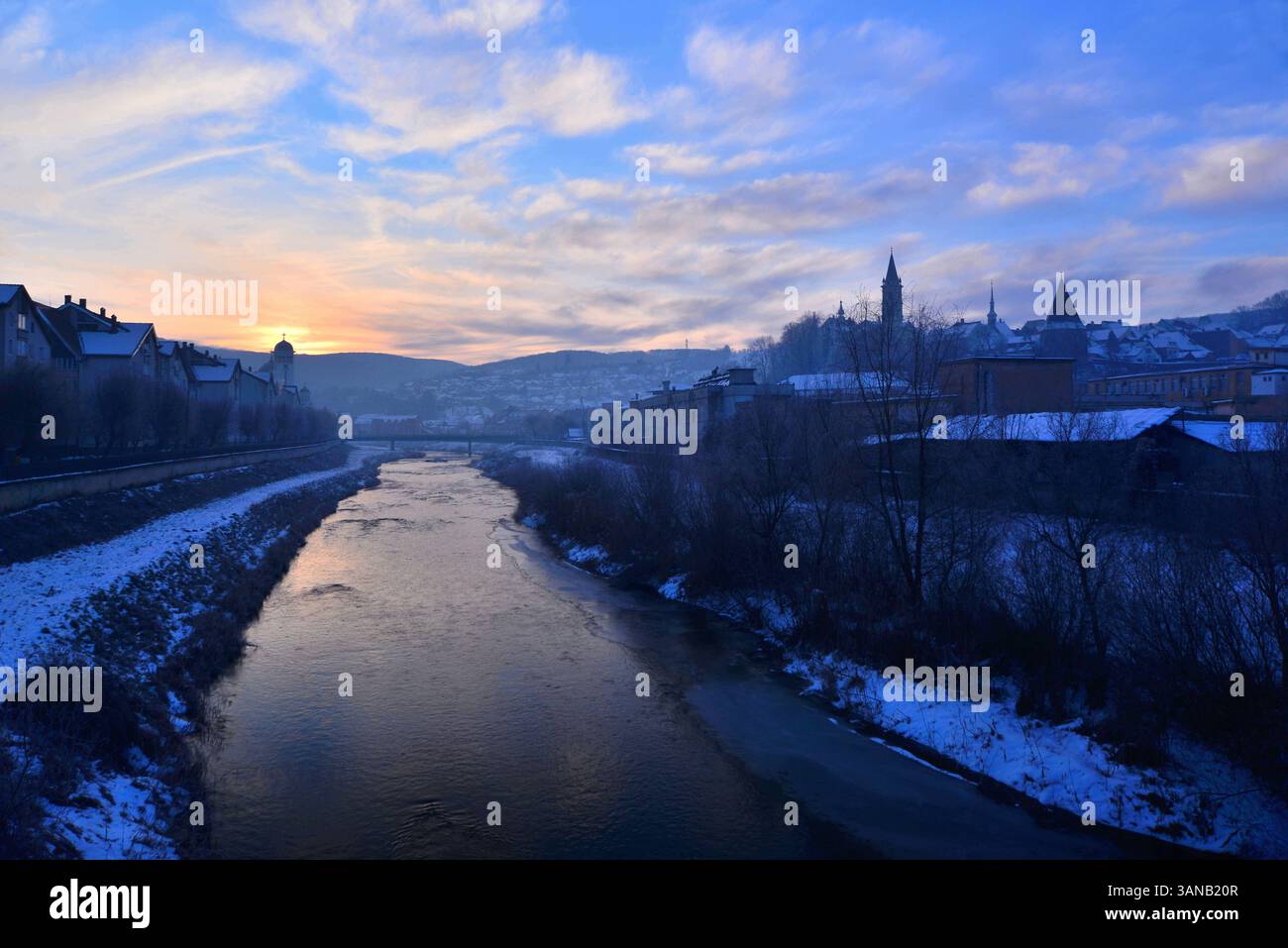 Prima luce dell'alba a Sighisoara con sagome delle torri della cittadella e del fiume Tarnava Mare Foto Stock