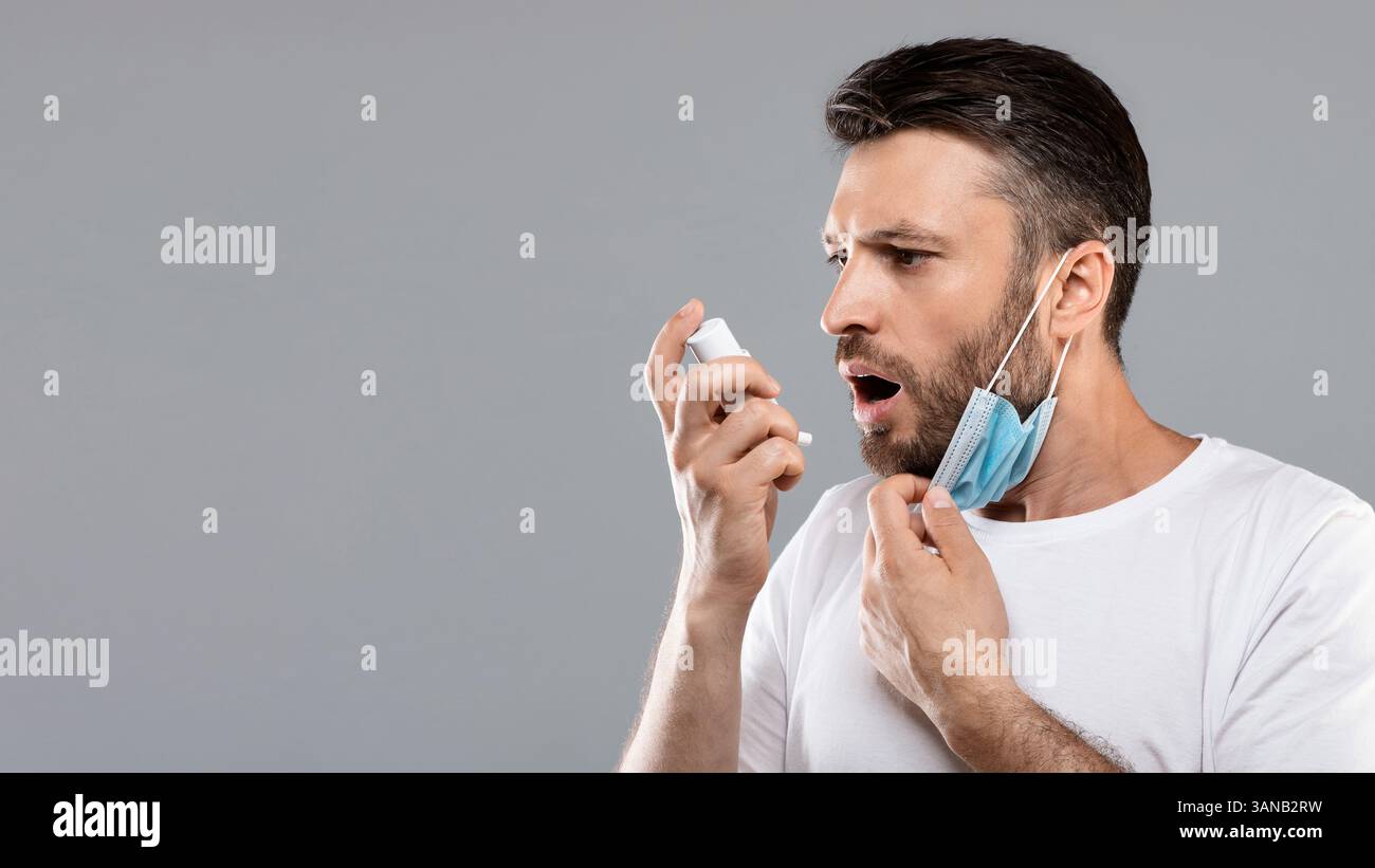 Ritratto dell'uomo con maschera protettiva con inalatore Foto Stock