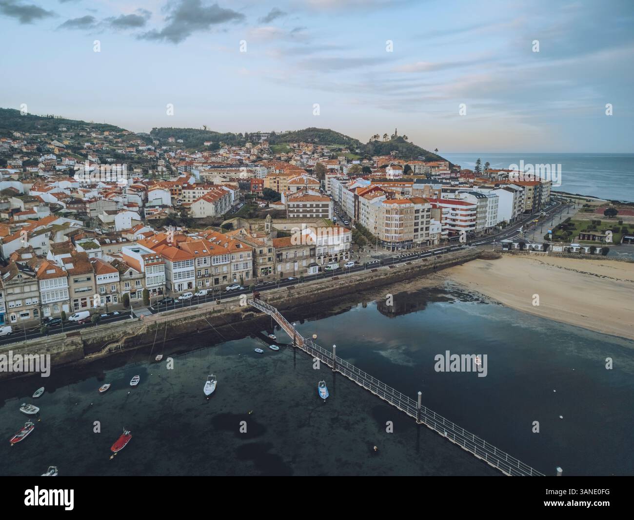 Vista aerea della splendida passeggiata sul lungomare con negozi e spiaggia sabbiosa nella storica città di Baiona, Spagna. Foto Stock