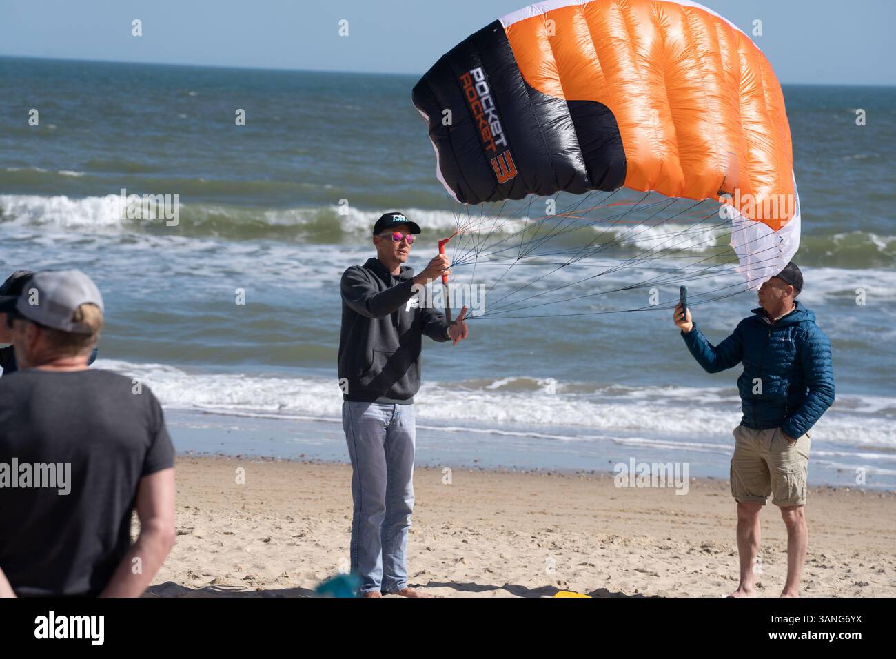 Un uomo pratica volando un aliscafo che pareggia su una spiaggia con il mare alle spalle. Foto Stock
