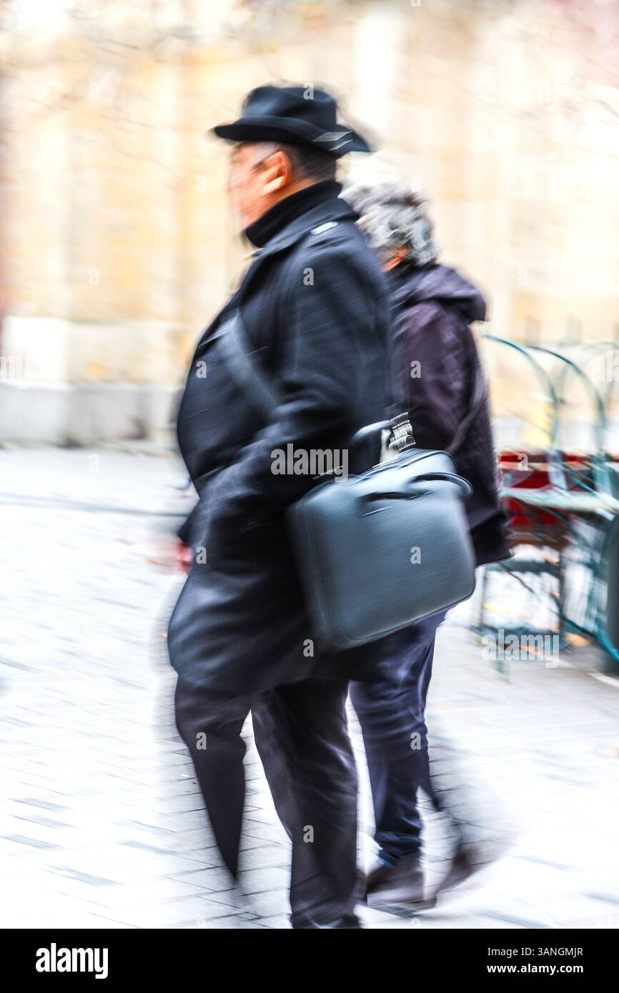 Uomo e donna che camminano insieme rapidamente producendo sfocature d'azione - Bruxelles, Belgio. Foto Stock