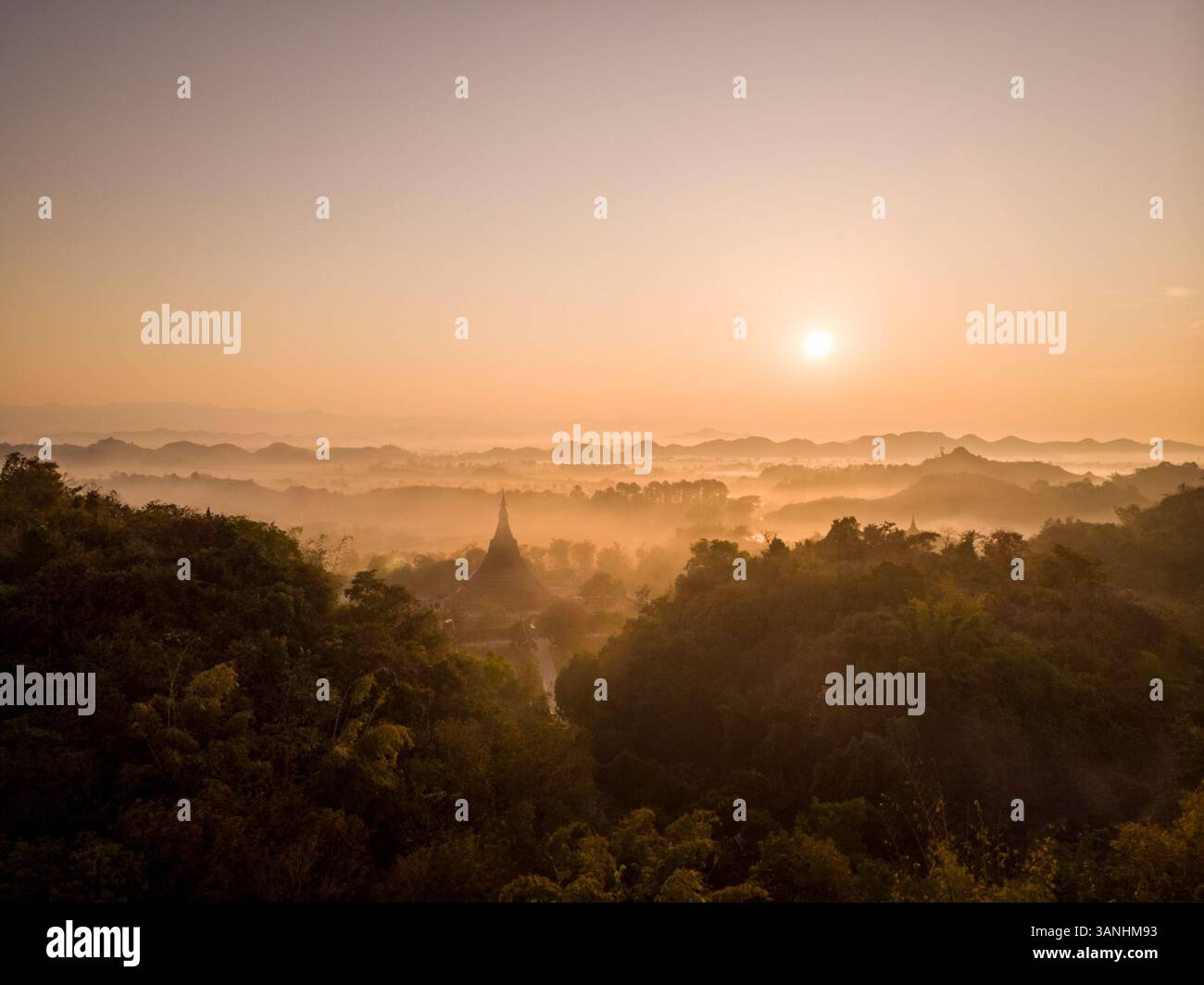 Vista aerea della pagoda Shin MRA War sulla cima della collina durante un bellissimo tramonto nebbioso, Mrauk-U Township, Myanmar. Foto Stock