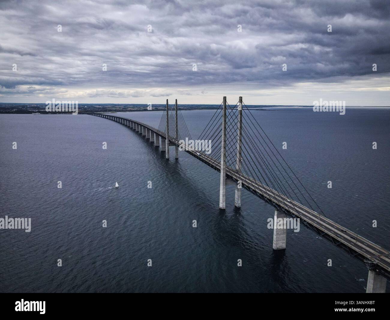 Veduta aerea della barca a vela sotto il ponte Oresund, in una drammatica giornata ventosa e nuvolosa, la Danimarca. Foto Stock