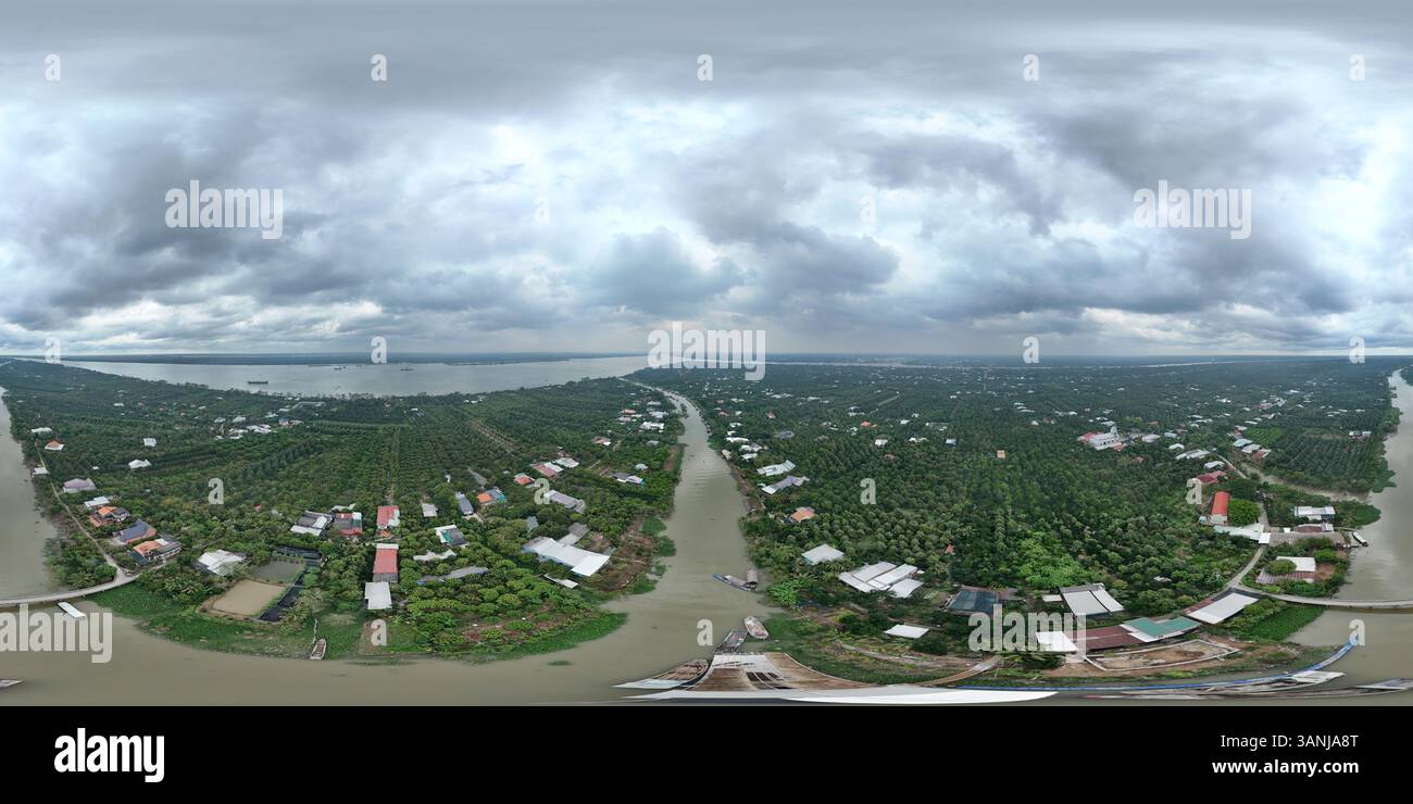 Vista aerea di un fiume panoramico inondato che si snoda attraverso un tranquillo villaggio circondato da lussureggianti campi e vegetazione, Tan Phong, Cai Lay, Tien Giang, vi Foto Stock