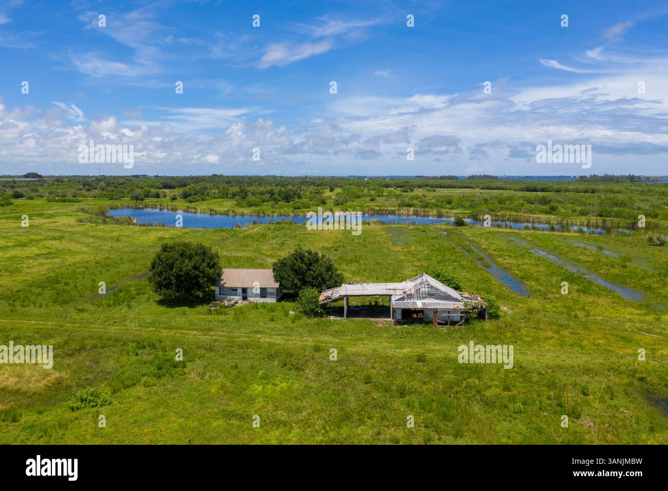 Vista aerea di una fattoria abbandonata vicino alla Old Dixie Highway con un lago sullo sfondo, St. Lucie County, Florida, Stati Uniti. Foto Stock