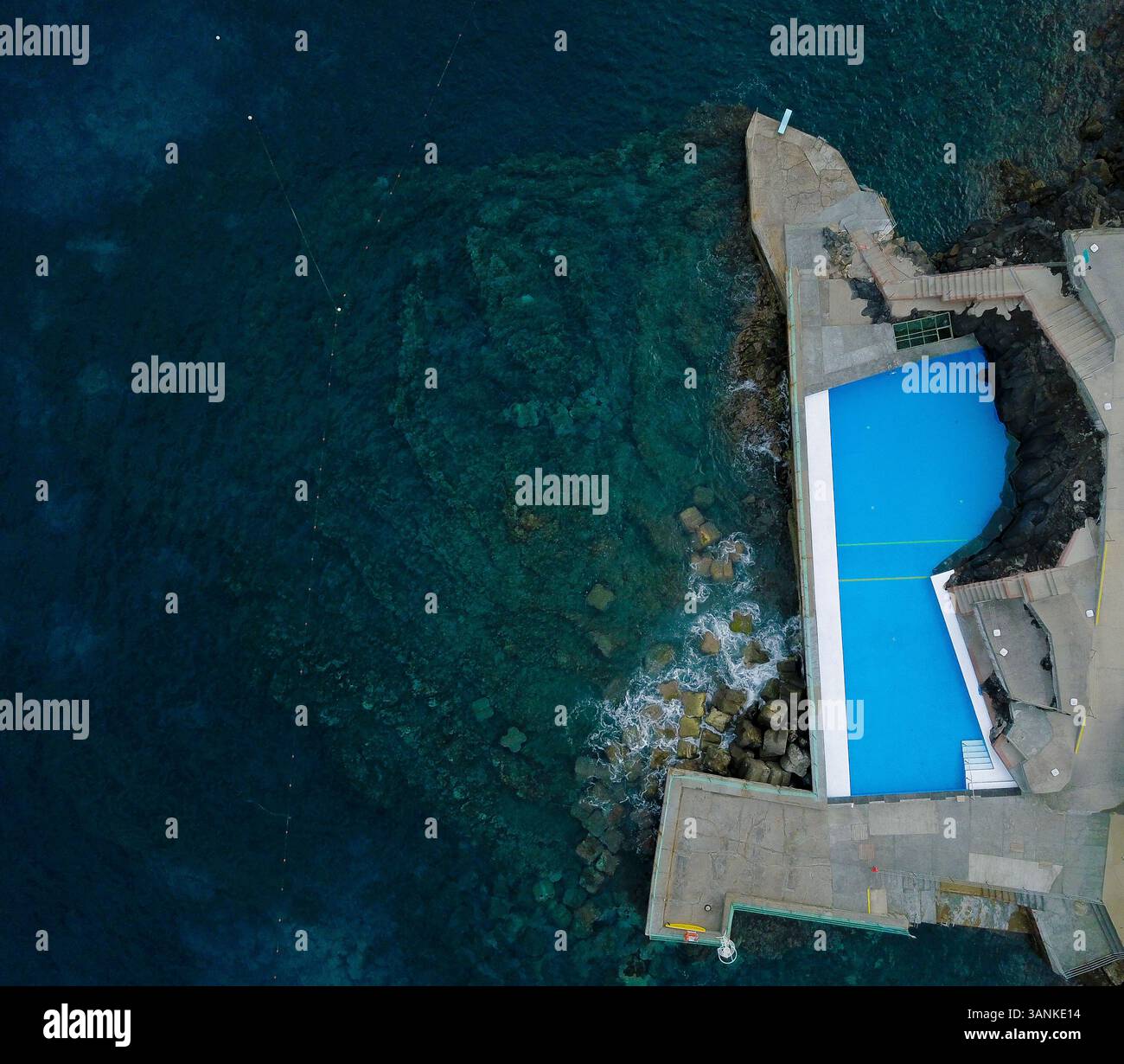 Vista aerea di un bellissimo hotel con una piscina limpida che si affaccia sull'oceano e sulle rocce, Funchal, Portogallo. Foto Stock