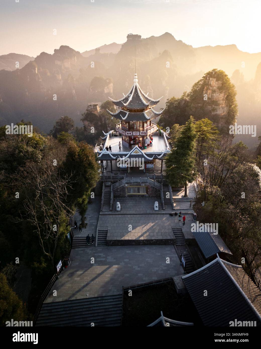Vista aerea di una pagoda storica e di un tempio circondato da montagne maestose e dalla tranquilla foresta, Zhangjiajie, Cina. Foto Stock