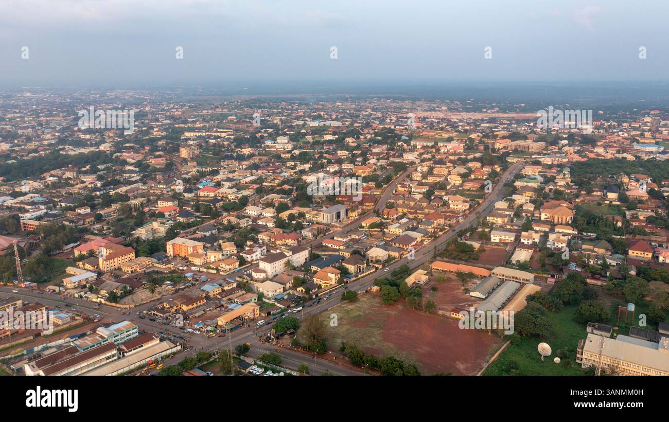 Vista aerea del paesaggio urbano con edifici residenziali e strade al tramonto, Enugu Nord, Nigeria. Foto Stock