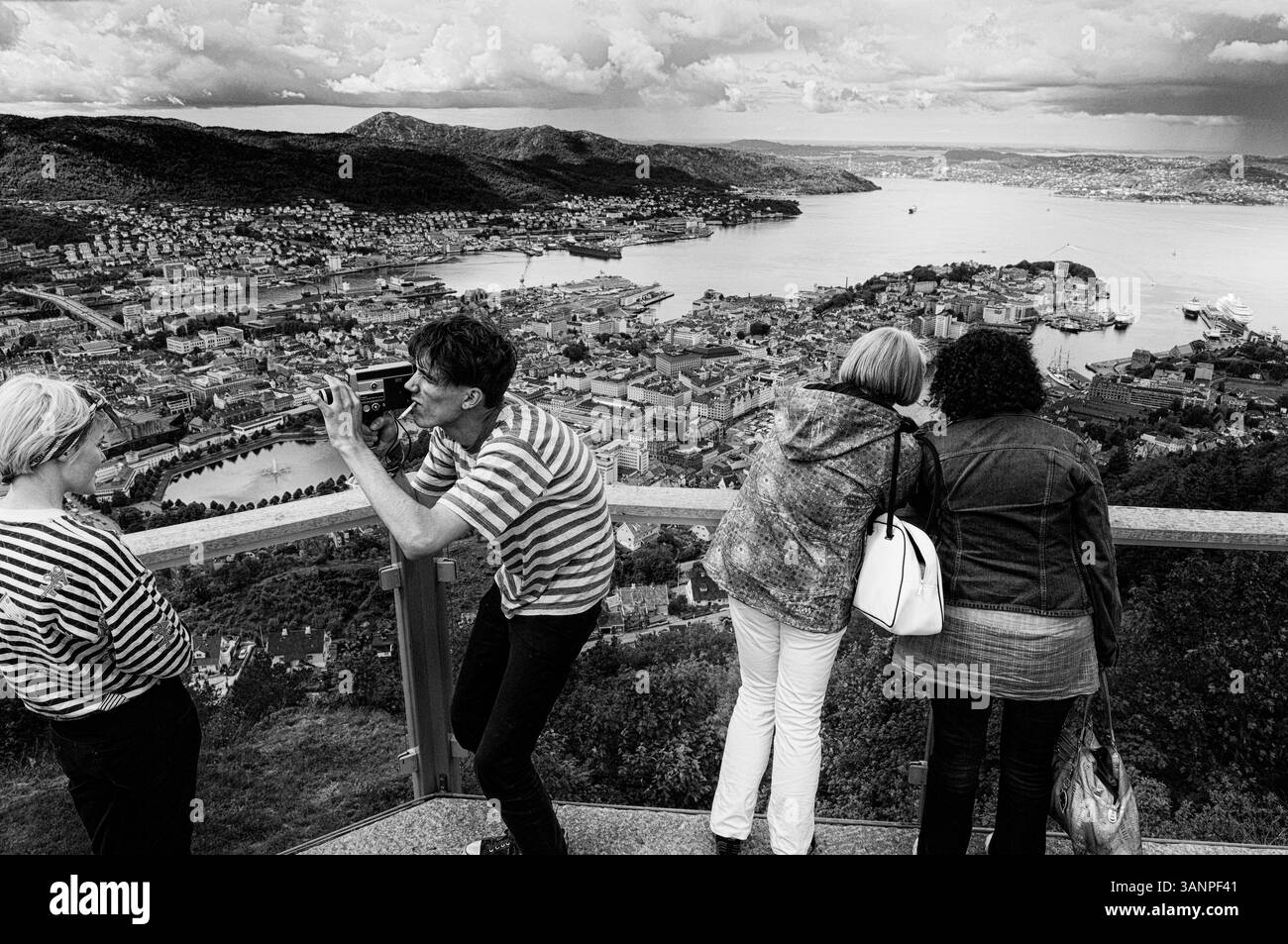 Una giovane coppia che utilizza una fotocamera Canon Auto Zoom 518 SV Super 8 vintage. Bergen vista dal Monte Floyen nella contea di Vestland sulla costa occidentale della Norvegia. Foto Stock
