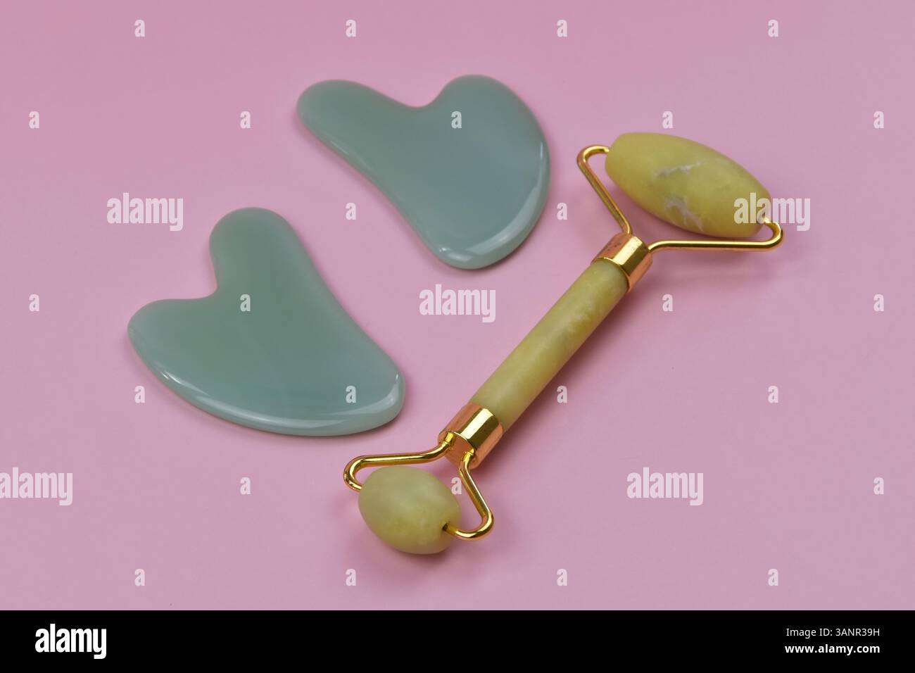 Primo piano del rullo facciale di giada e della pietra di gua Sha per trattamenti di benessere e bellezza, utilizzati per sollevare e rassodare la pelle Foto Stock