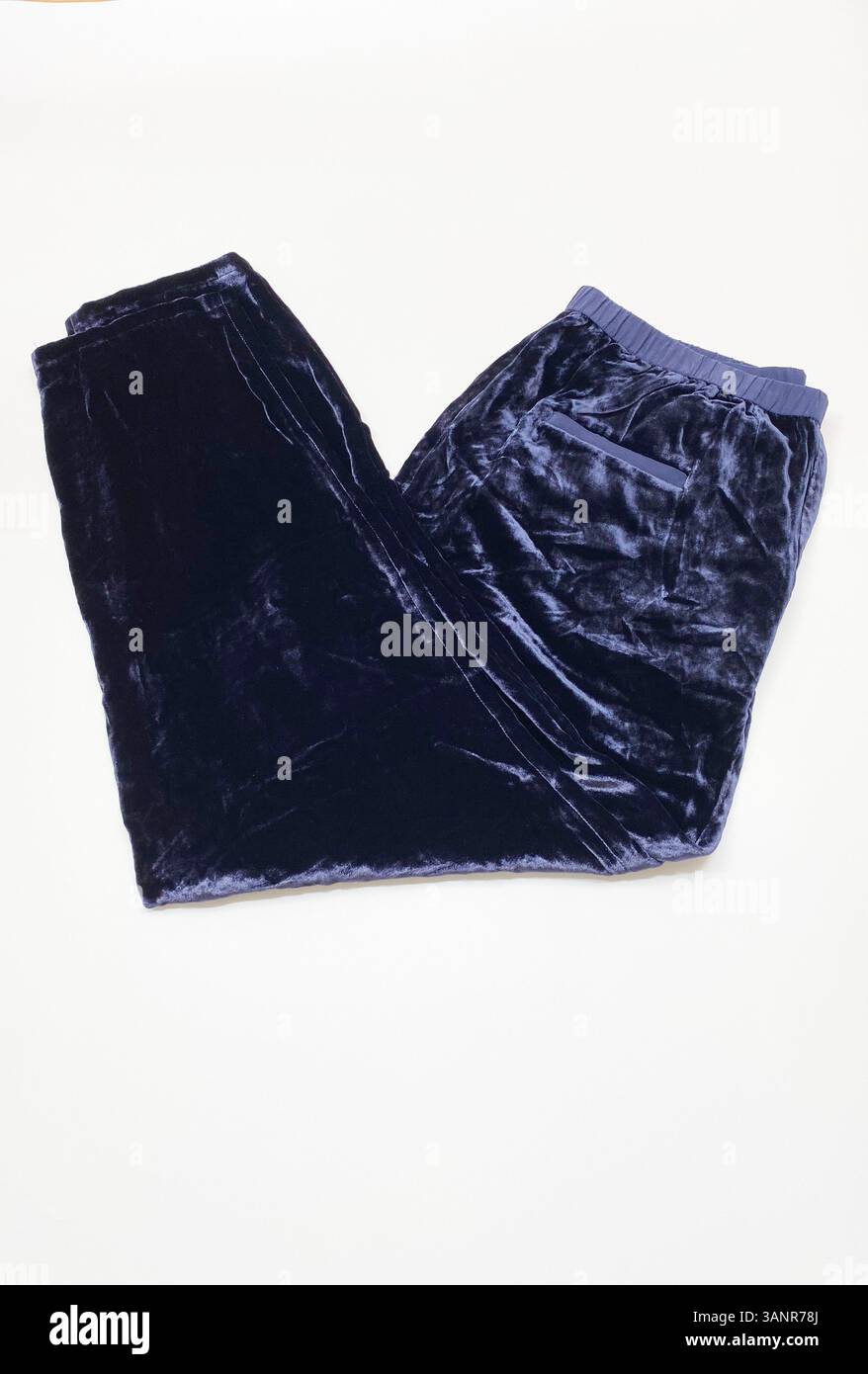 Un paio di pantaloni in velluto scuro su sfondo bianco studio. Foto Stock