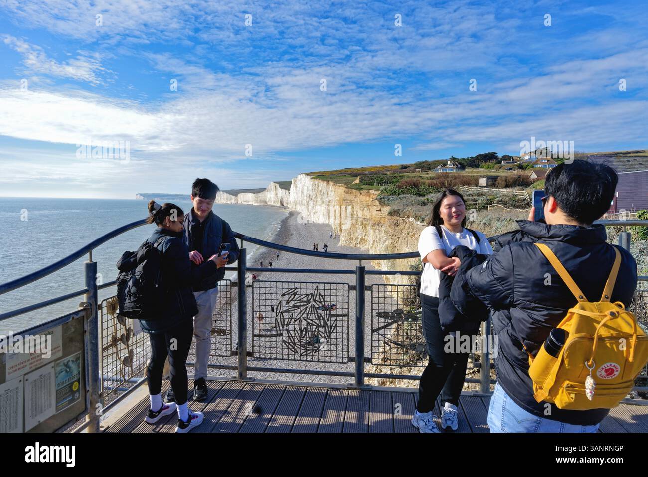 Turisti asiatici che visitano la costa meridionale di Birling Gap nel South Downs National Park in una giornata di primavera soleggiata, vicino a Eastbourne East Sussex Inghilterra, Regno Unito Foto Stock