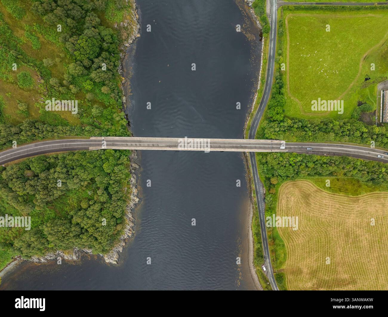 Vista aerea di Loch Creran con un ponte e una strada tortuosa circondata da vegetazione lussureggiante e acque tranquille, Oban, Scozia. Foto Stock