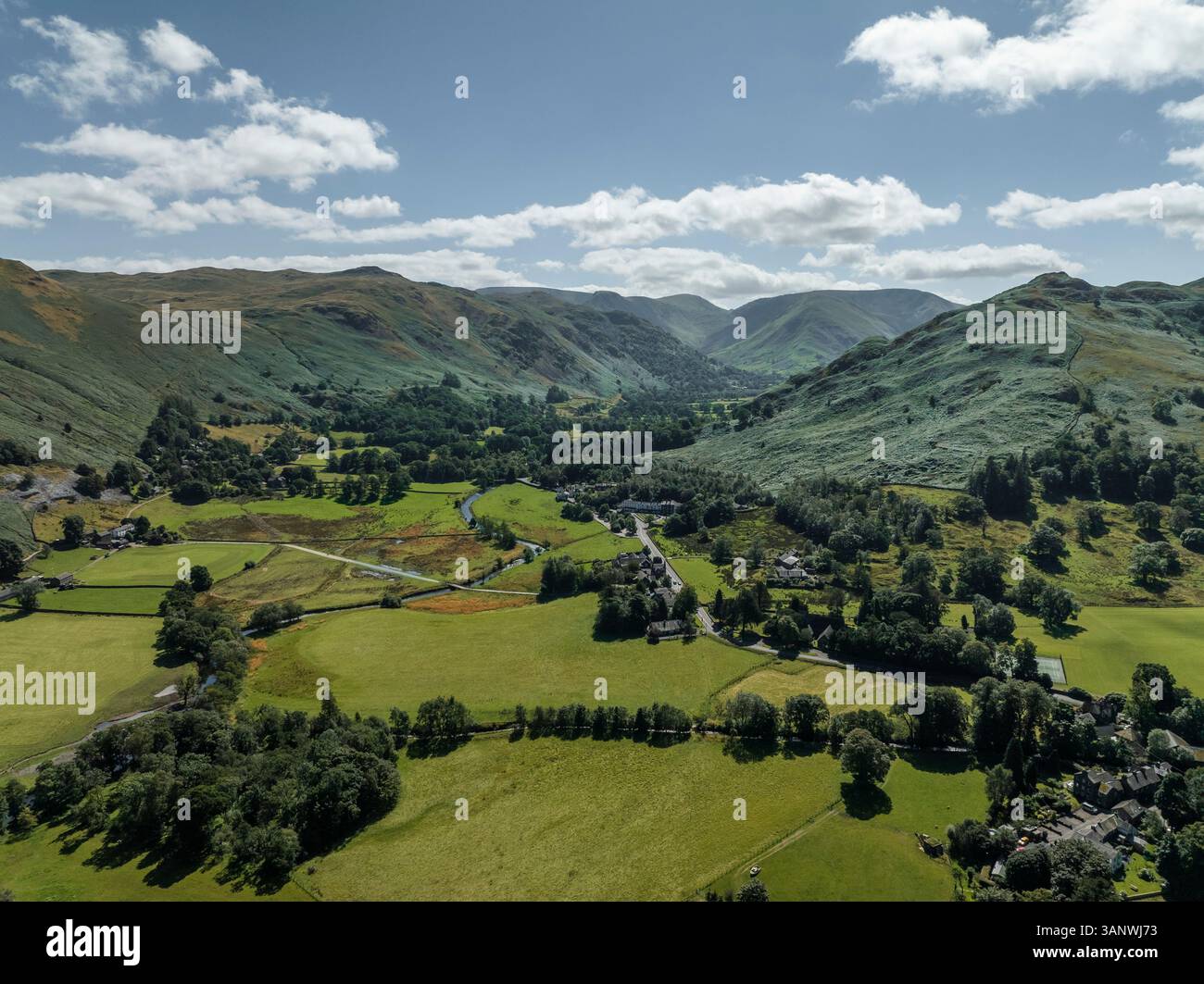 Vista aerea di tranquille e pittoresche colline e valli con campi lussureggianti e un pittoresco villaggio, Patterdale, Inghilterra. Foto Stock