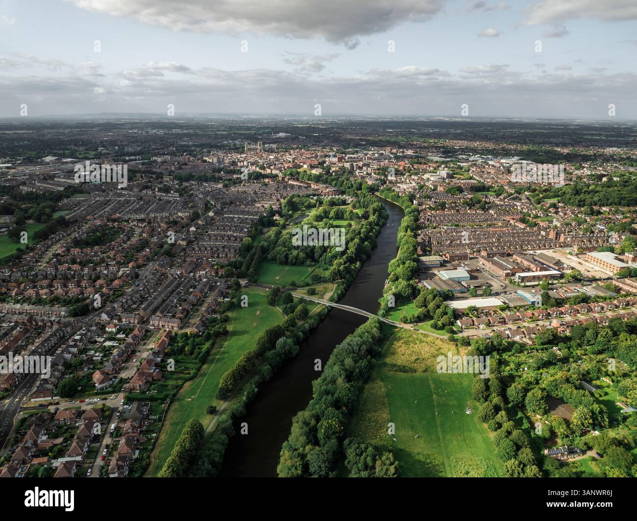 Vista aerea di un paesaggio urbano panoramico con un fiume, vegetazione lussureggiante e case residenziali, York, Inghilterra. Foto Stock