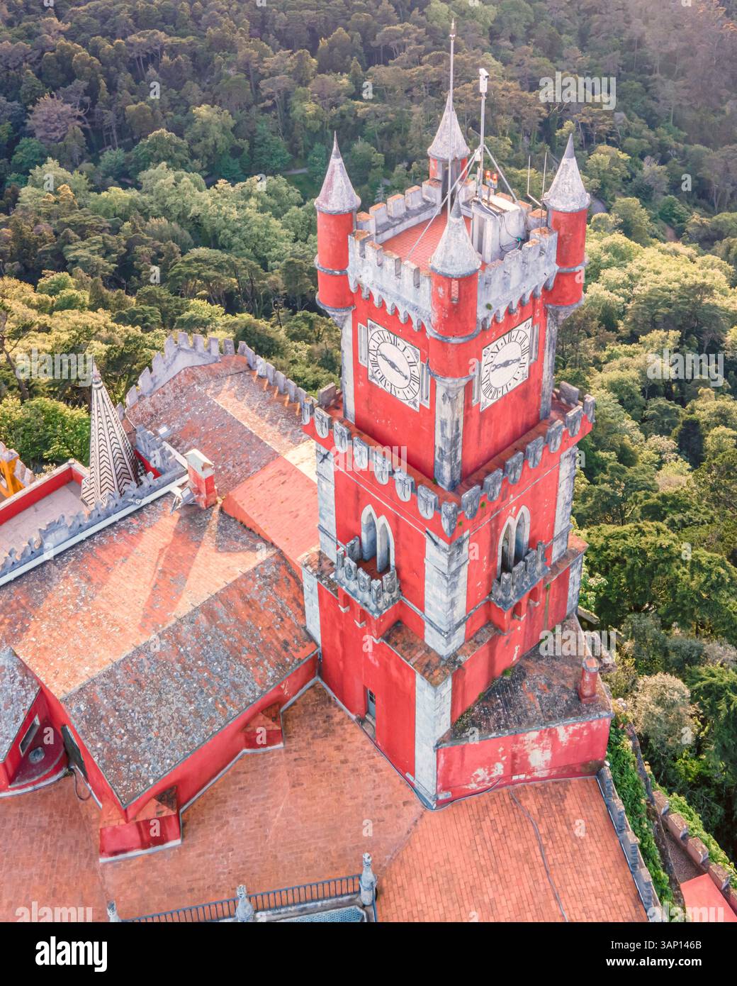 Vista aerea della torre dell'orologio del castello di pena con la foresta sullo sfondo, vista del castello romanticista sulla collina, Sintra, Lisbona, Portogallo. Foto Stock