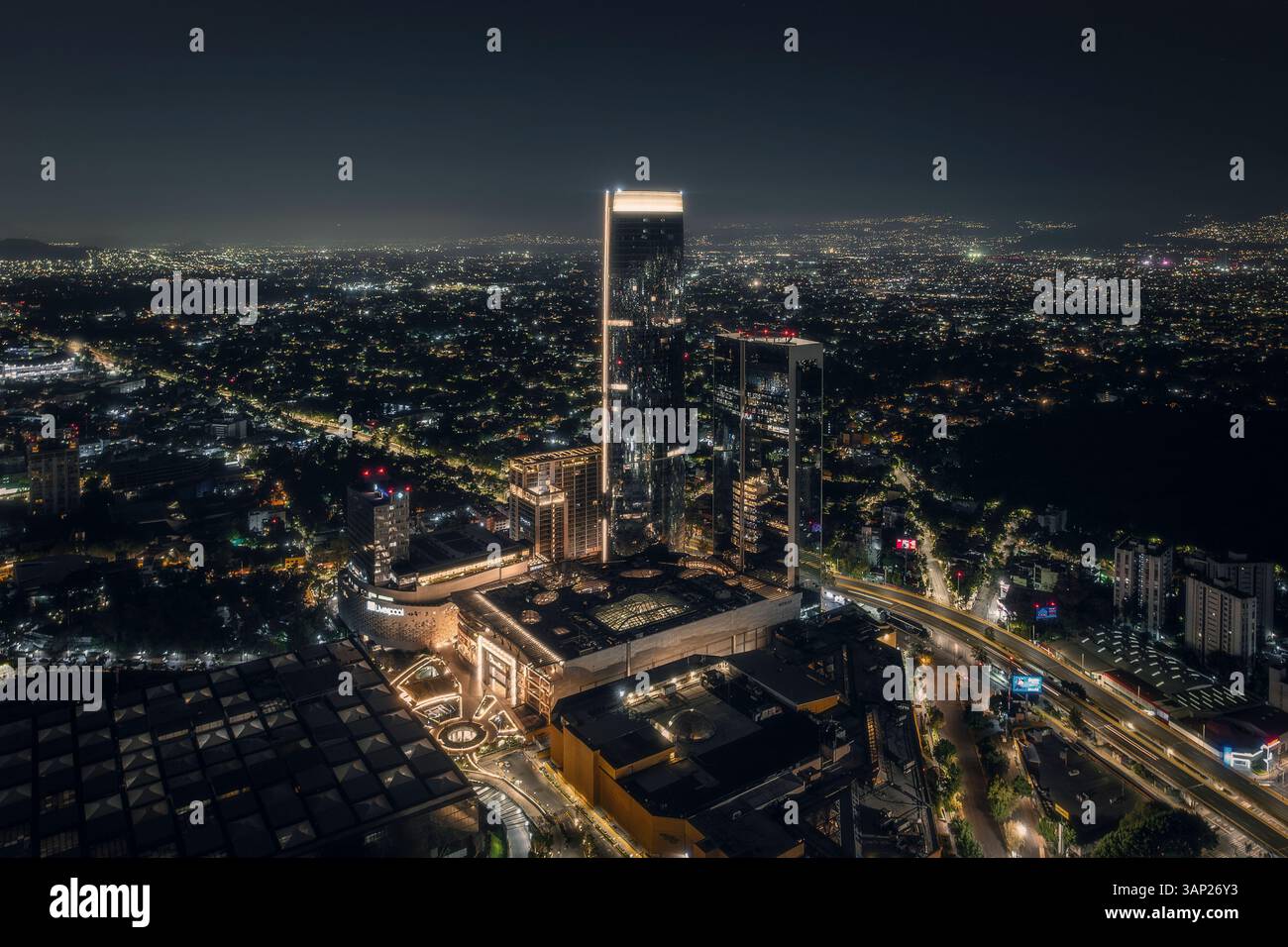 Vista aerea della torre della mitikah illuminata di notte con un vivace paesaggio urbano e la vivace vita urbana, benito juarez, messico. Foto Stock
